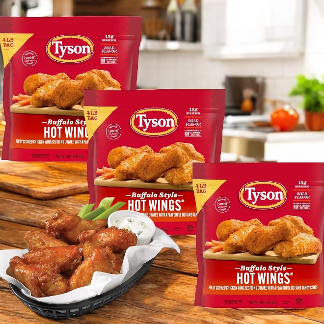 On the kitchen counter are three bags of Tyson Buffalo Style Hot Wings, with a plate showcasing spicy, fully cooked wings smothered in savory buffalo sauce in the foreground.