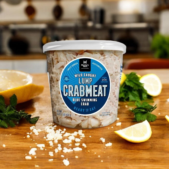 A Member's Mark Wild Caught Premium Lump Crab Meat container graces the kitchen counter, surrounded by lemon wedges and fresh herbs, offering a true delight for seafood lovers who appreciate sustainably sourced ingredients.