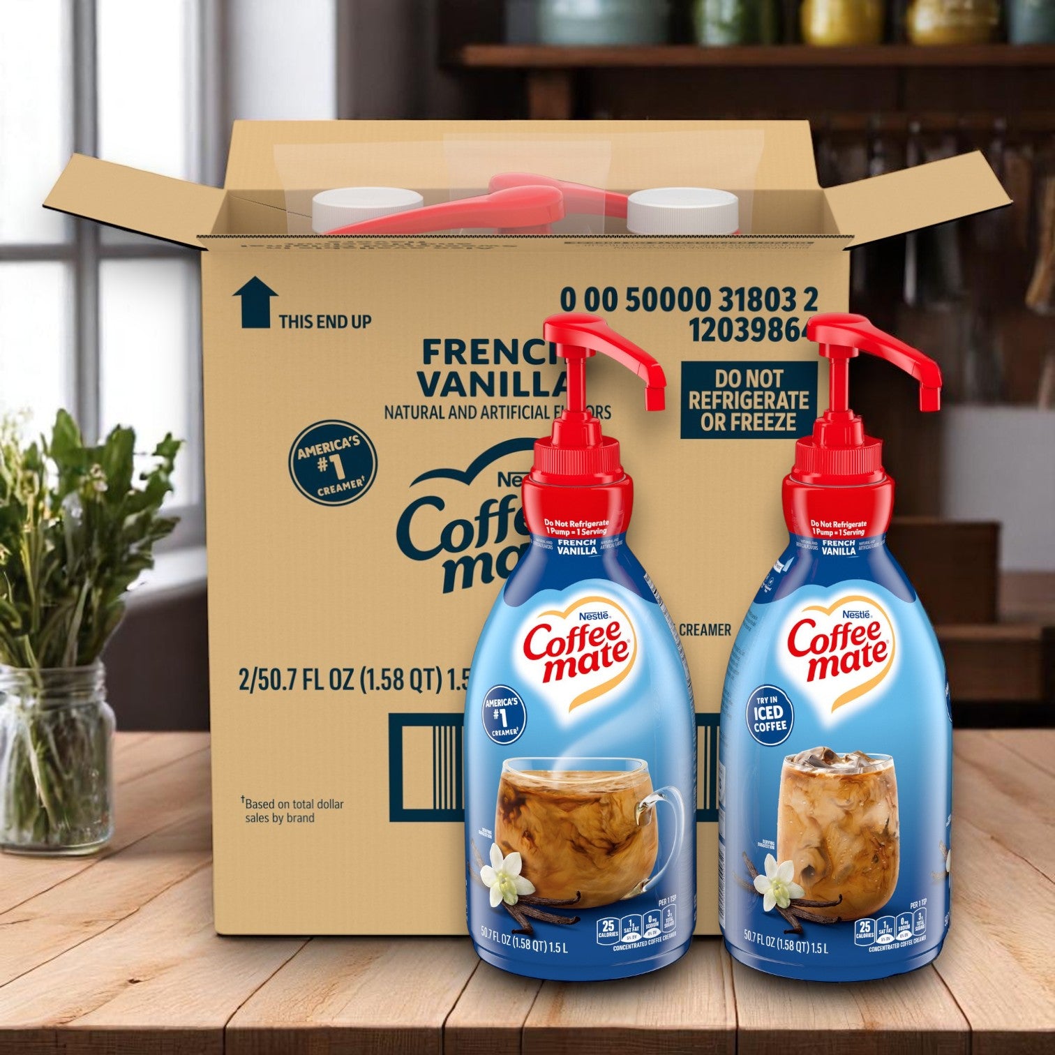 Two Coffee Mate French Vanilla Liquid Creamer pump bottles (1.5L each) are displayed in front of a cardboard shipping box on a kitchen counter.