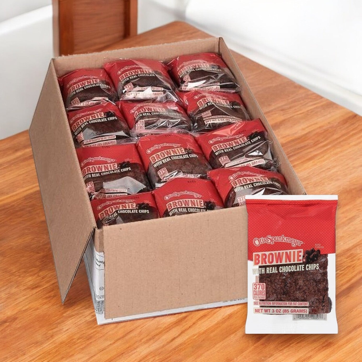 An enticing box of Otis Spunkmeyer Brownies showcases a prominently labeled package, "Brownie with Real Chocolate Chips," each 3-ounce treat promising a rich chocolate flavor in every bite. 48 brownies per case.
