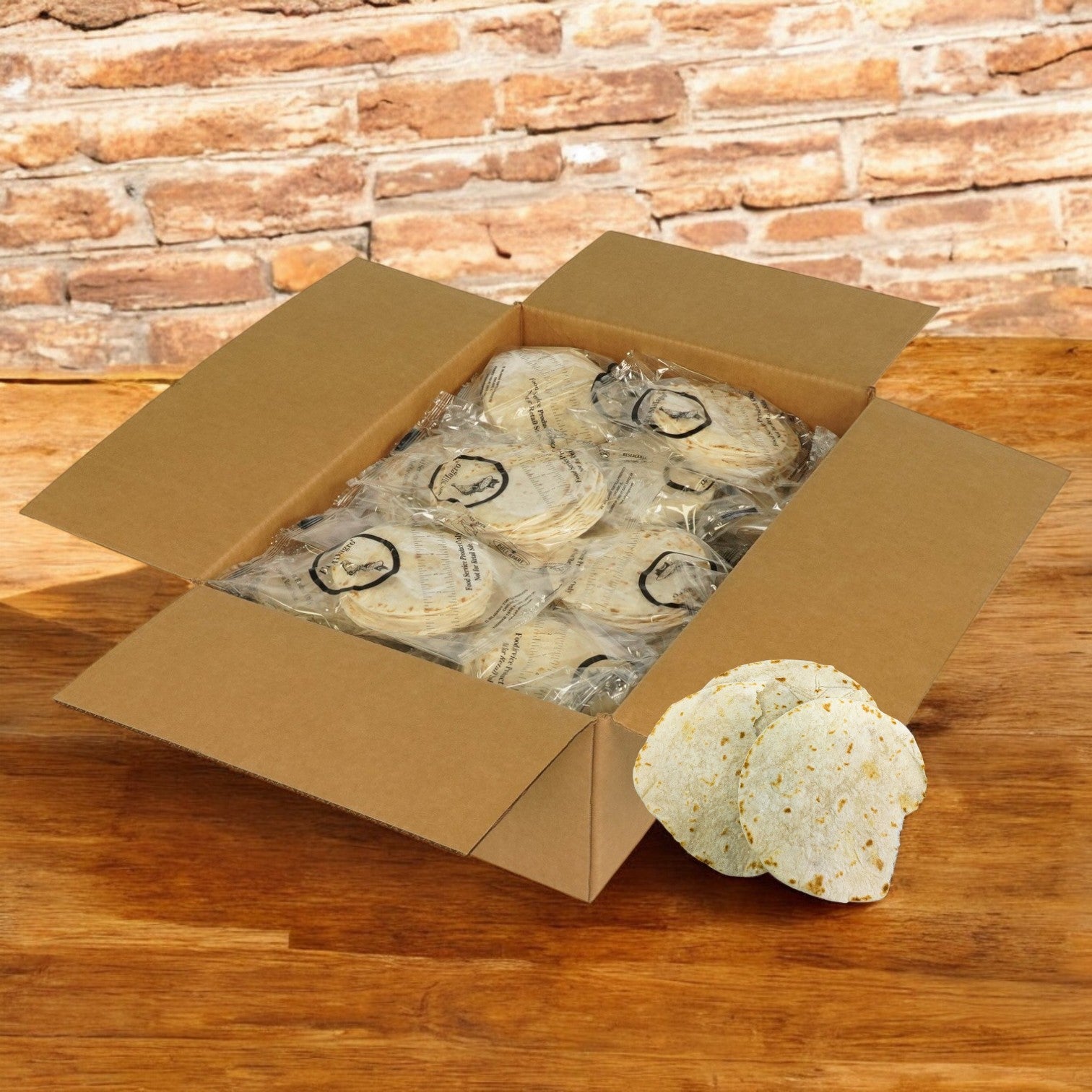 A box of El Milagro White Flour Tortillas (5-Inch, 42 packs of 1 dozen) sits on a wooden surface, with several clear plastic packs and some tortillas outside the box. Ships on Mondays—plan accordingly!.