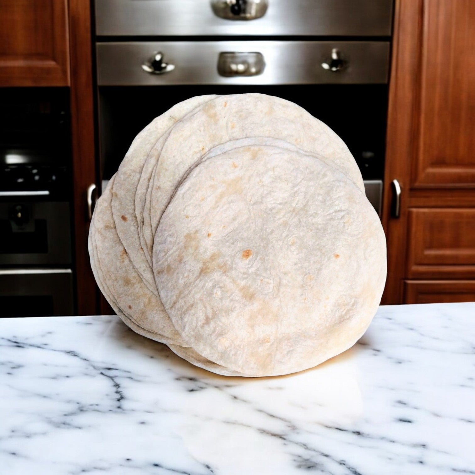 A stack of three El Milagro 8-inch Flour Tortillas sits on a marble countertop, framed by wooden cabinets and a stainless steel oven, promising to enhance any meal with their authentic taste.
