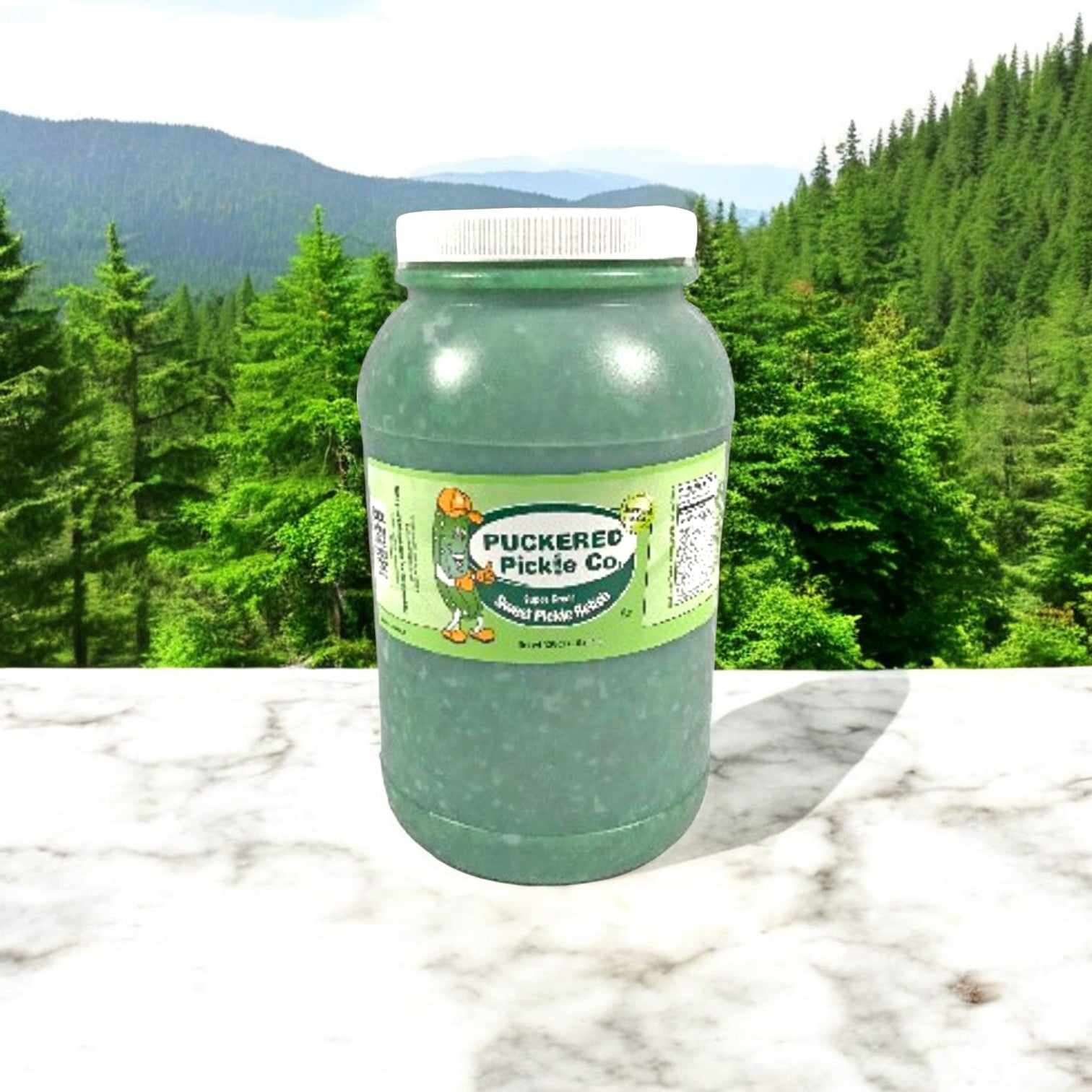 A 1-gallon jar of Puckered Pickle Relish Sweet Green Bright by Puckered Pickle Co. sits on a marble surface, promising a tangy flavor. Forest and mountain scenes in the background inspire its versatile use in various dishes.