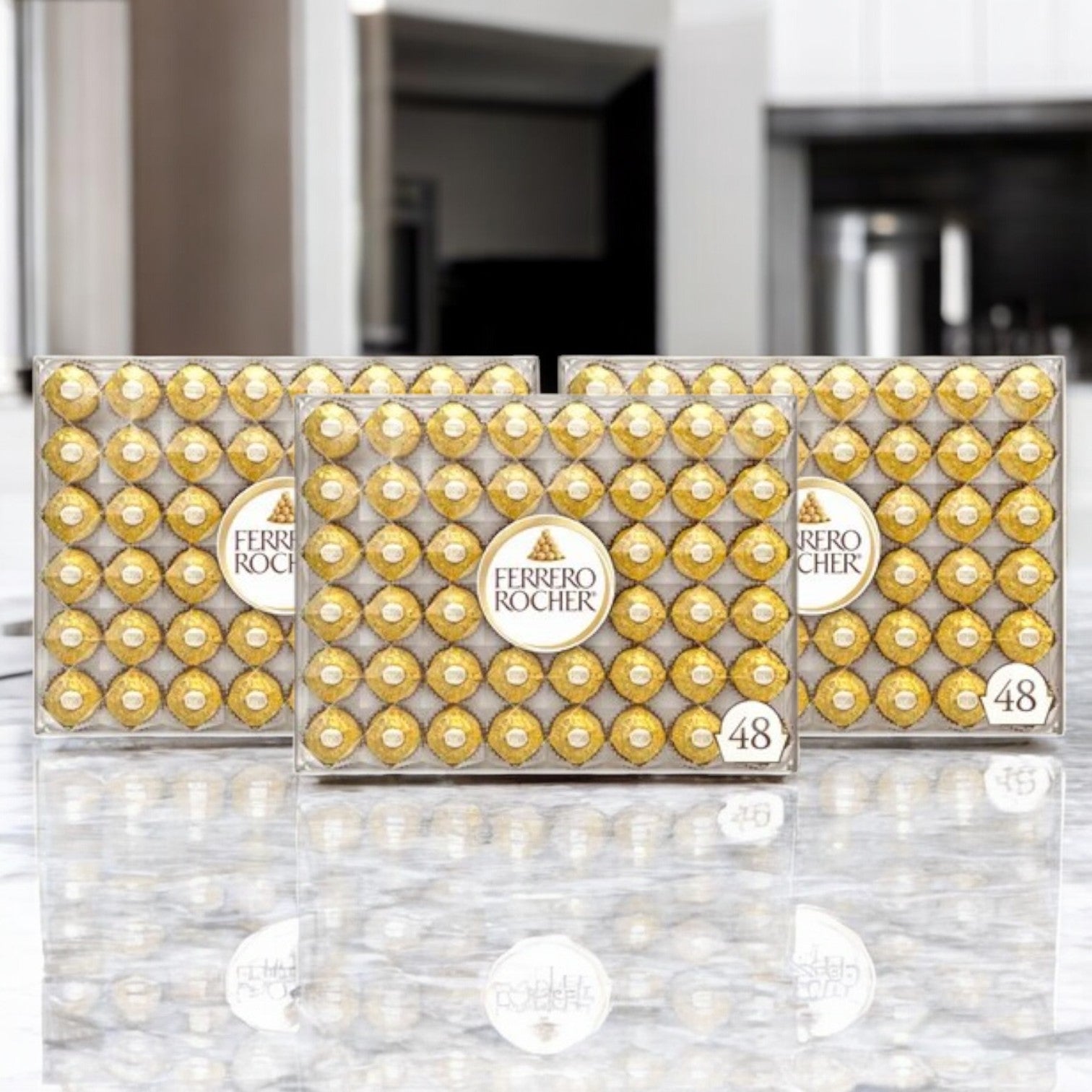 Three boxes of Ferrero Rocher Milk Chocolate Hazelnut Candy, each with 48 pieces, are displayed on a reflective marble surface.