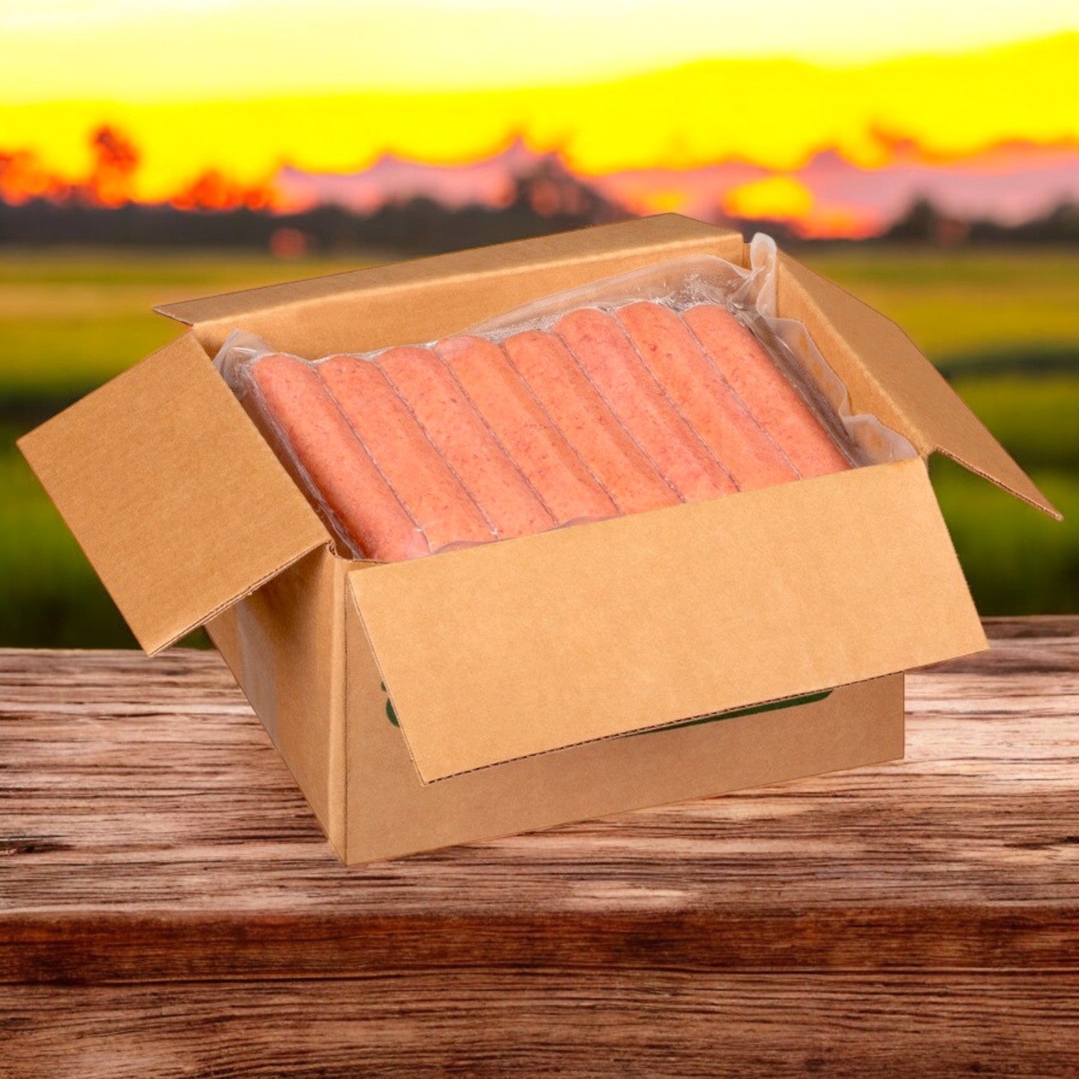 An open cardboard box of Nathan’s Famous Sausage Polish - 10 lbs. case holds 50 packaged franks on a wooden surface, set against a blurred sunset background, highlighting their premium quality.
