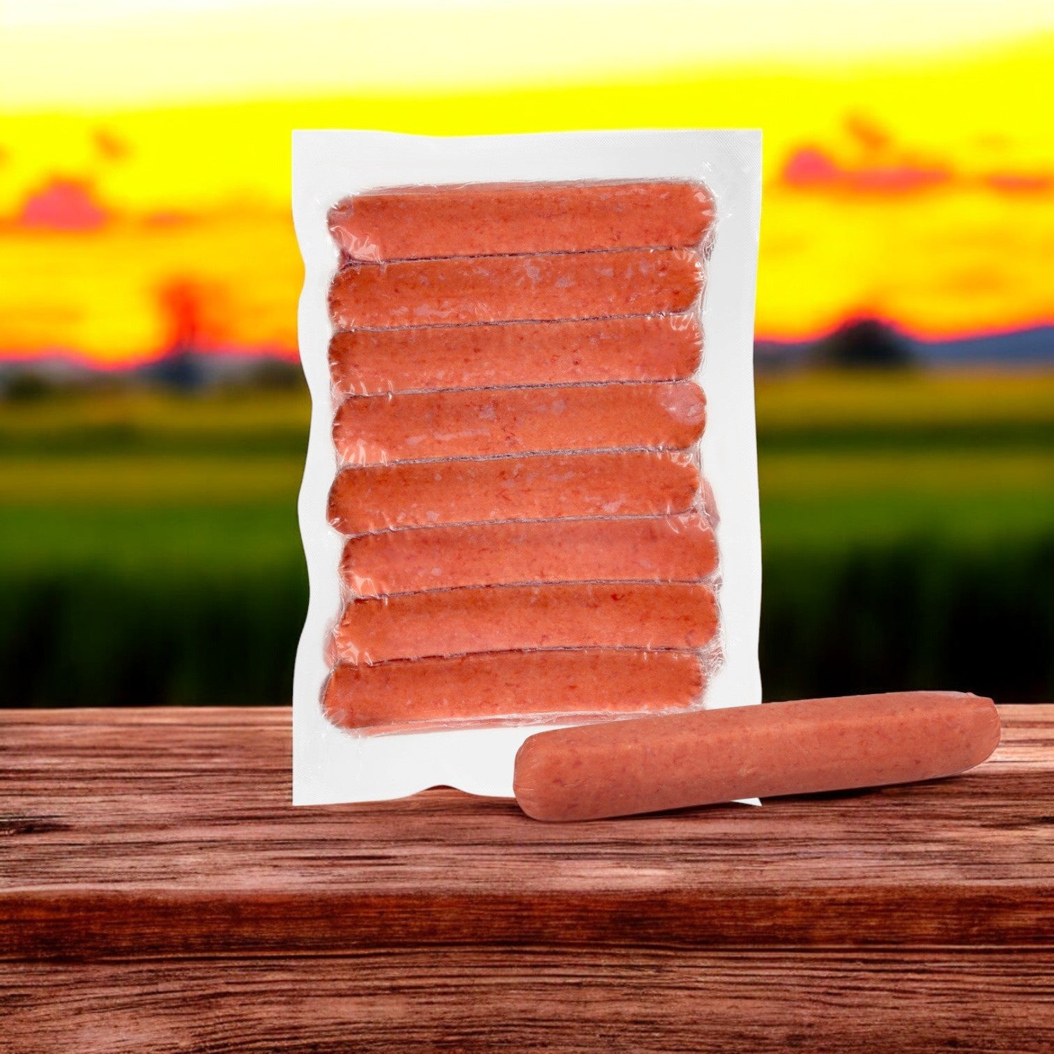 A breathtaking sunset over lush fields frames a premium pack of Nathan's Famous Polish Sausages, with one sausage displayed elegantly on a wooden surface.