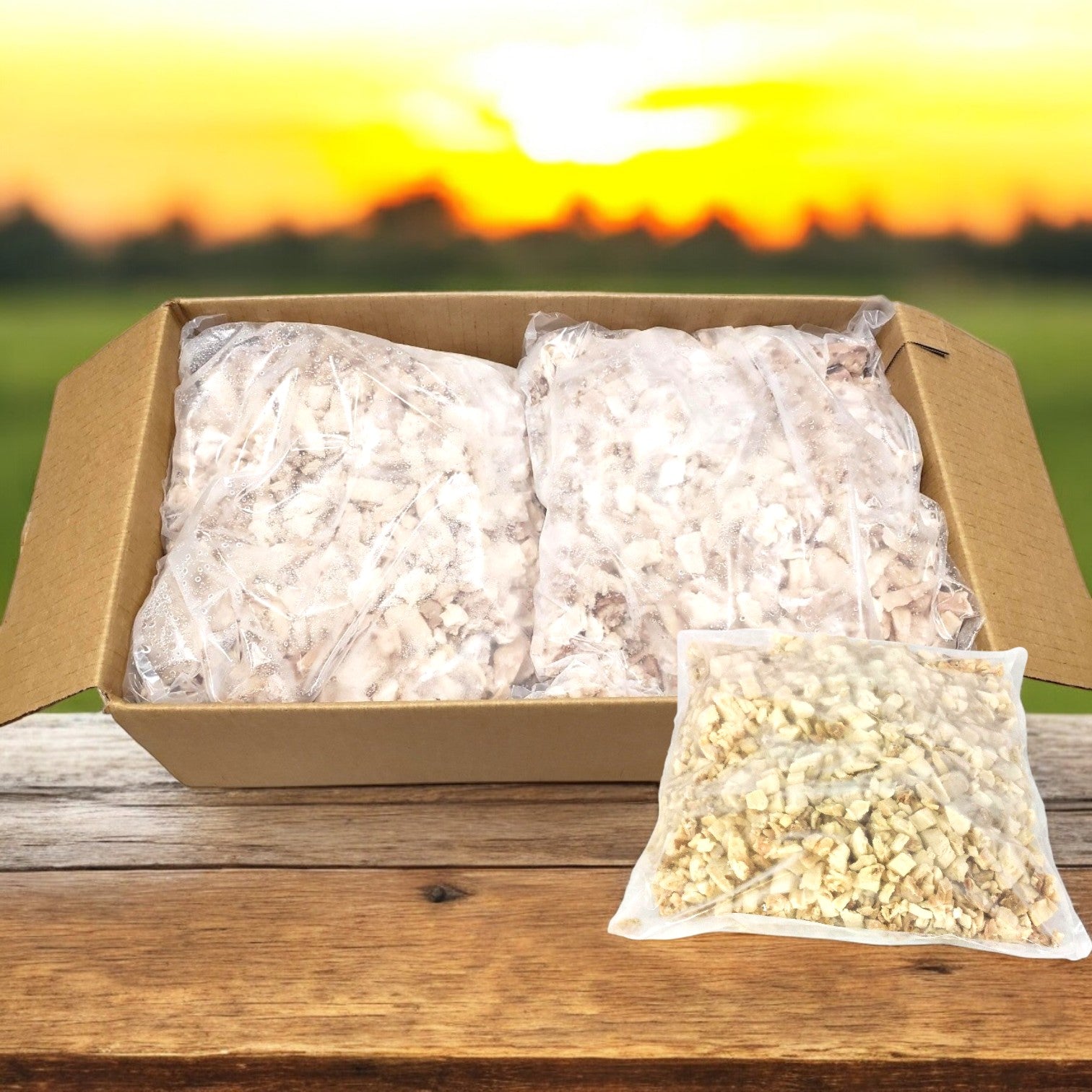 A Sysco Classic cardboard box contains sealed plastic bags of chopped dried mushrooms, prominently displayed. A smaller bag sits in front with Sysco Diced Chicken Meat, 0.5 Inch White & Dark, Low Sodium – 2/5 LB, all under the warm glow of a sunset over the field.
