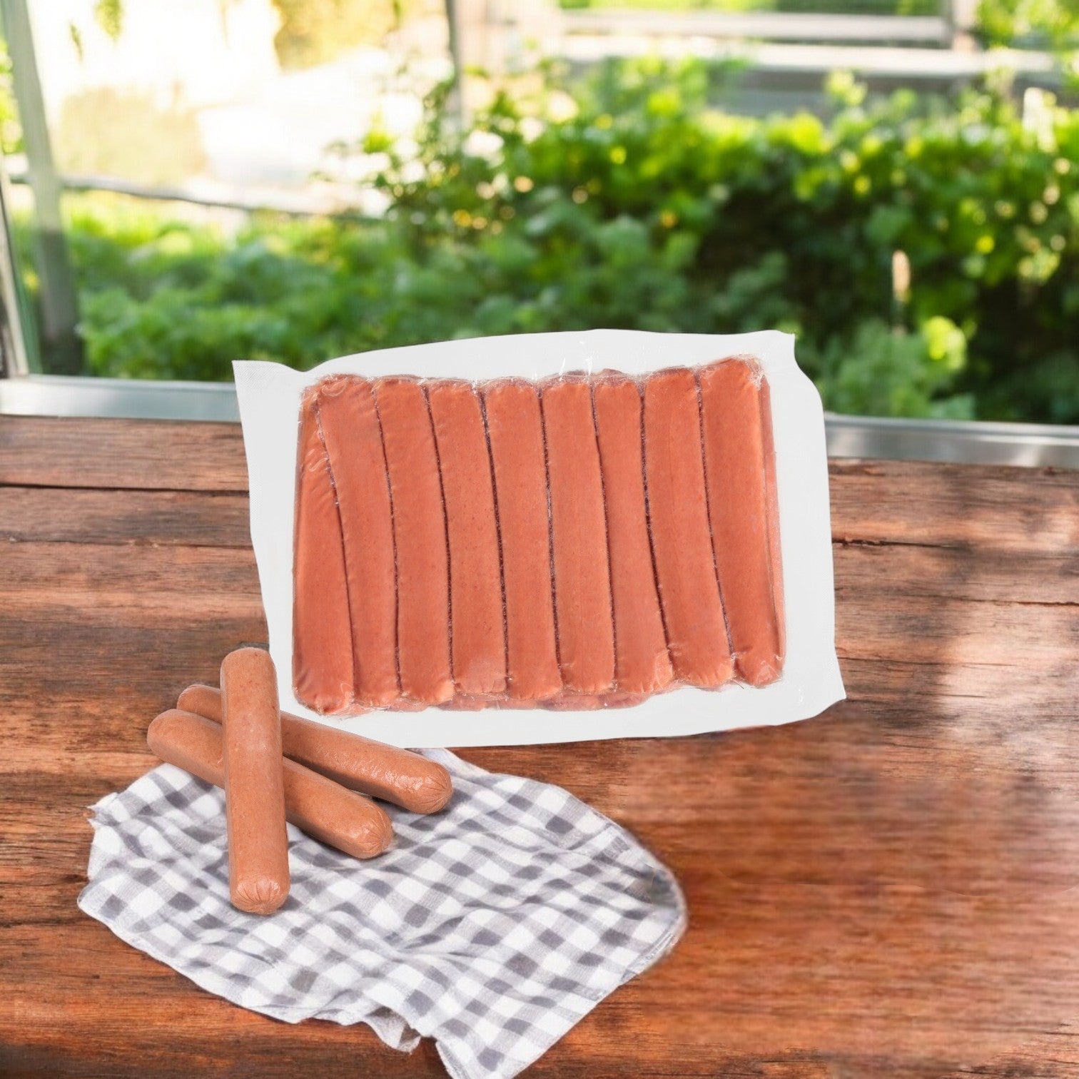 A pack of Nathan's Famous Nathan's Frankfurter All-beef, 6"-50 Franks A Case lies on a wooden surface outdoors. Three unwrapped hot dogs next to a checkered napkin await grilling in front of the pack.