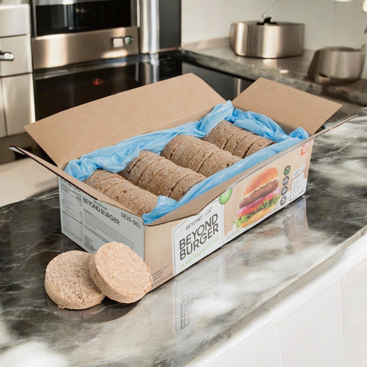 On the kitchen counter, a cardboard box holds several Beyond Meat Burger Vegetarian Beyond Patties, featuring their delicious pea protein blend.