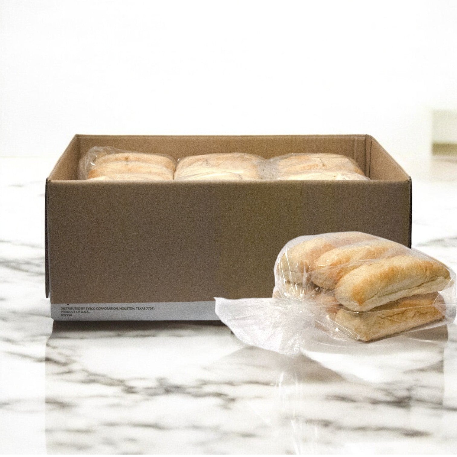 A box of Papa Charlie's 32 Sandwich Combo, which includes buns and giardiniera, sits on a marble countertop, with one sandwich set beside it, ready to be transformed into the perfect roast beef sandwich.