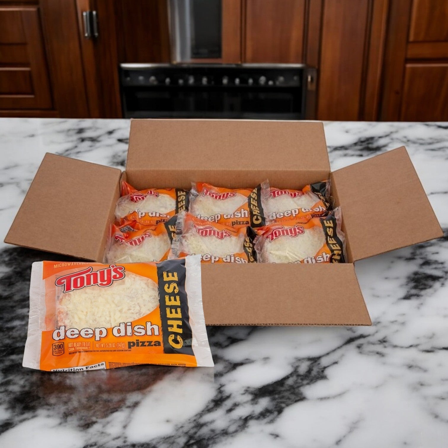 A box of Tony's Round 5" Cheese Pizza, 24 Count, from Tony's Pizza sits on a marble countertop in front of a stove, ready for quick meals.