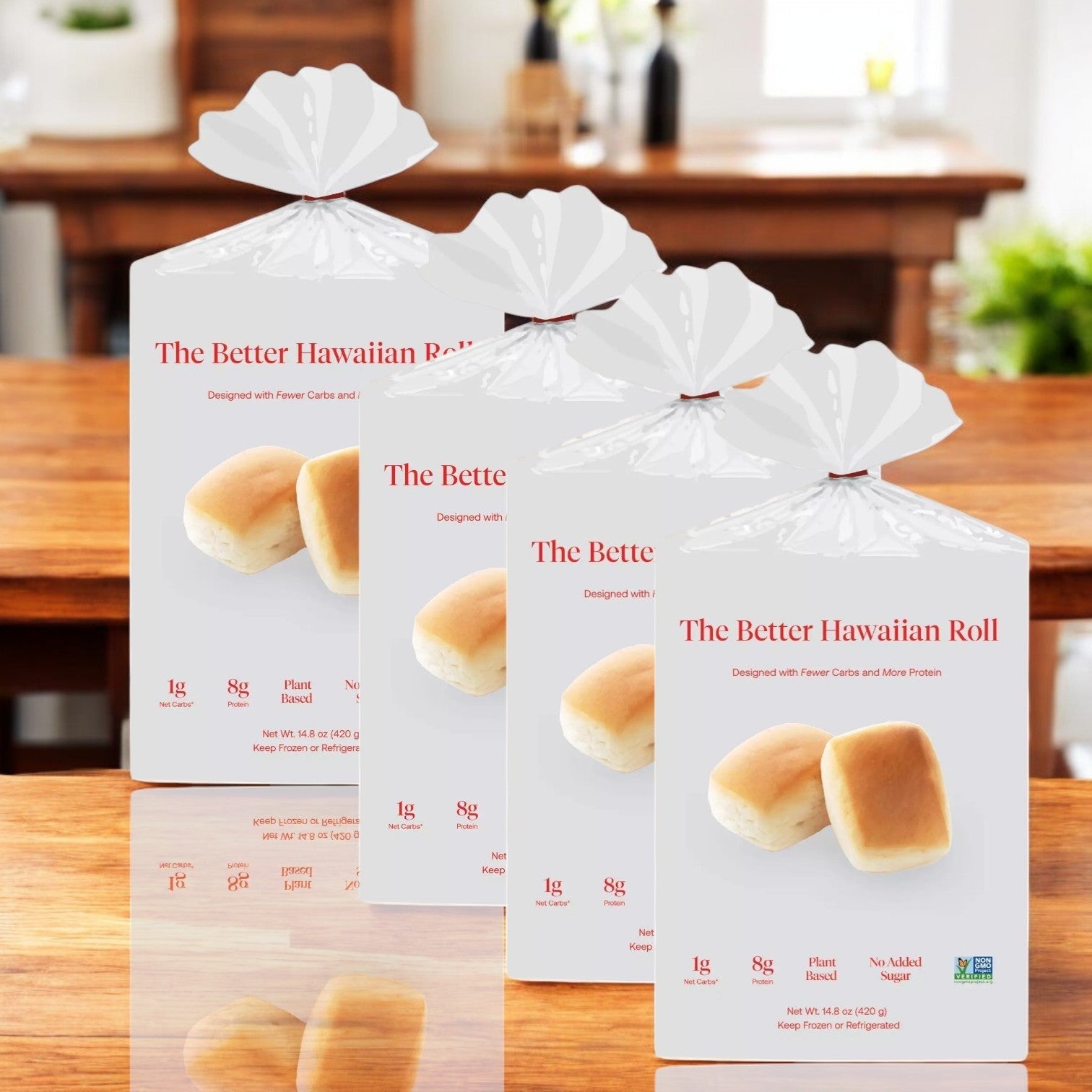 Four packs of "Better Brand - The Better Hawaiian Roll, Pack of 12 - 4 Bags Total" are showcased on a wooden table in a bright room. The packaging emphasizes low carbs, plant-based ingredients, high protein, and zero added sugar—perfect for any meal. In stock and ready to ship!.
