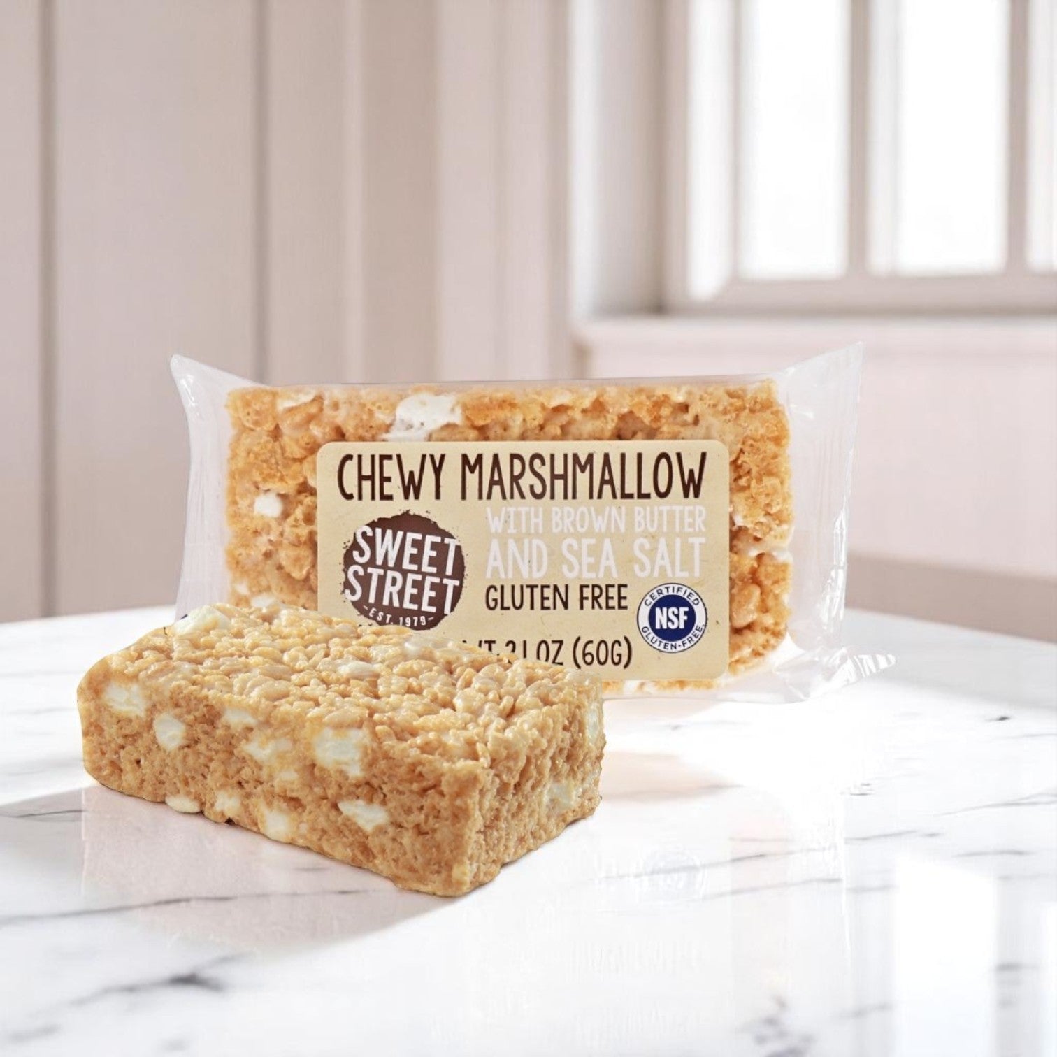 A Sweet Street Rice Crispy Snack Bar – Brown Butter & Sea Salt Gluten-Free sits unwrapped on a marble counter, highlighting its chewy texture. Box contains 40 bars, each 2.1 oz.