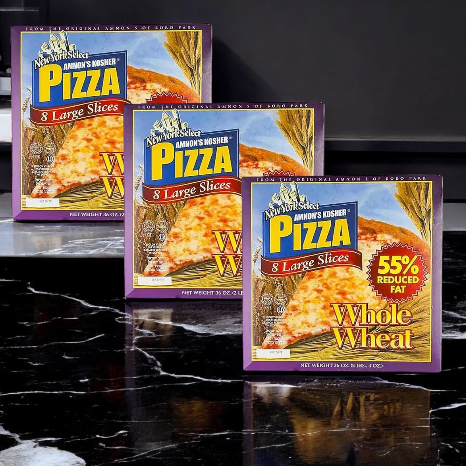 Three boxes of Amnon's Kosher Pizza Whole Wheat Low Fat Frozen, 36 oz. - 3 Count are displayed on a marble surface, featuring "8 Large Slices," "Whole Wheat," and "55% Reduced Fat," ideal for anyone looking for a tasty low-fat pizza choice.