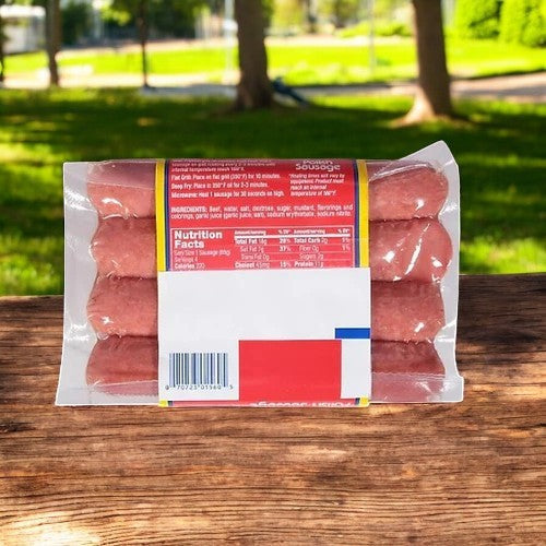 A pack of Vienna Beef Polish Sausage-12 oz-3 Count, with nutrition facts and ingredients visible, rests on a wooden surface. In the background, a serene park with lush trees enhances the scene. Made from seasoned beef and pork by Vienna Beef, these sausages promise exceptional flavor.