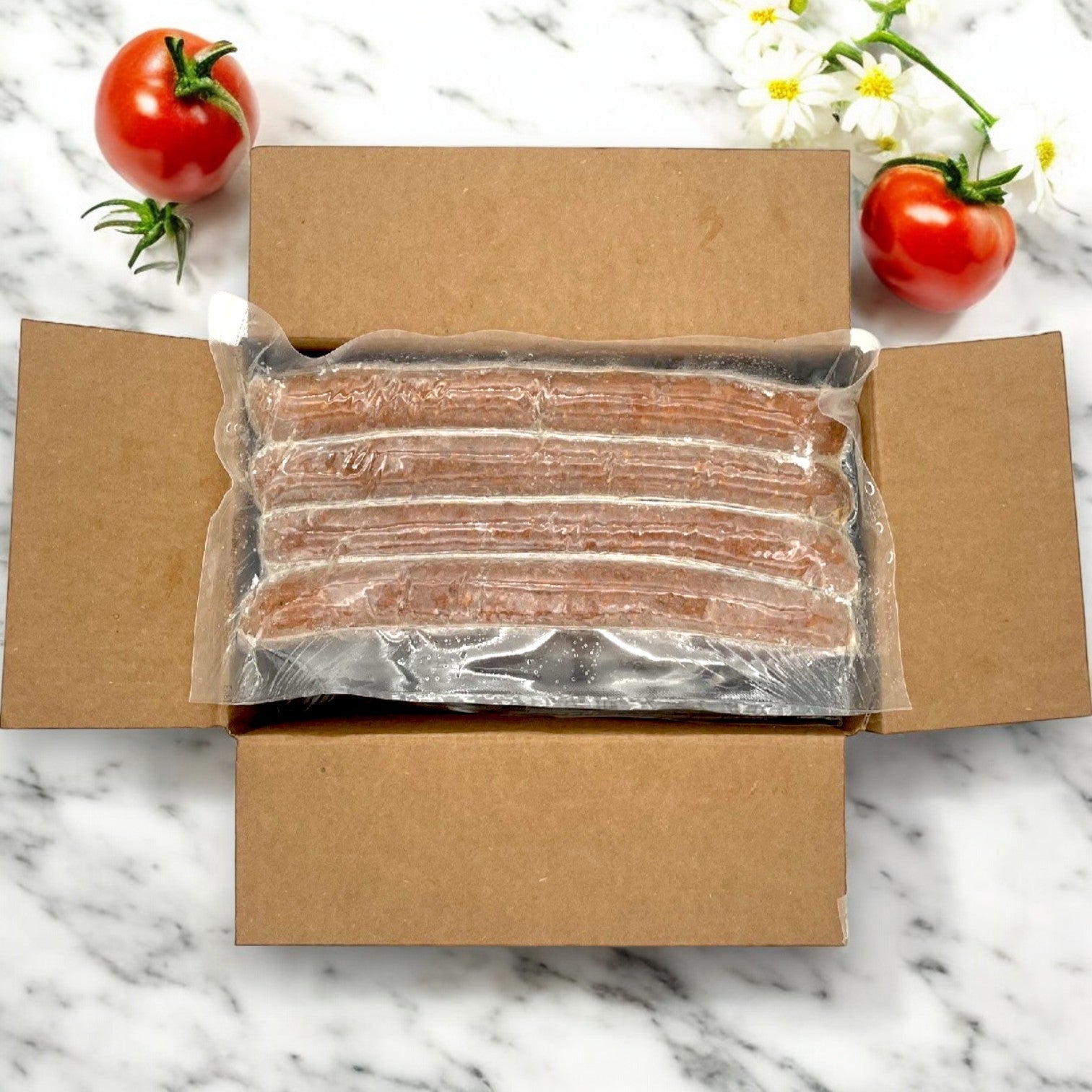 The Amylu Sausage Chicken Andouille Links, packaged in a 10 lb. box, bring a hint of Cajun flavor with vacuum-sealed convenience. Enjoy fully cooked links amidst tomatoes and white flowers on marble for culinary delight.