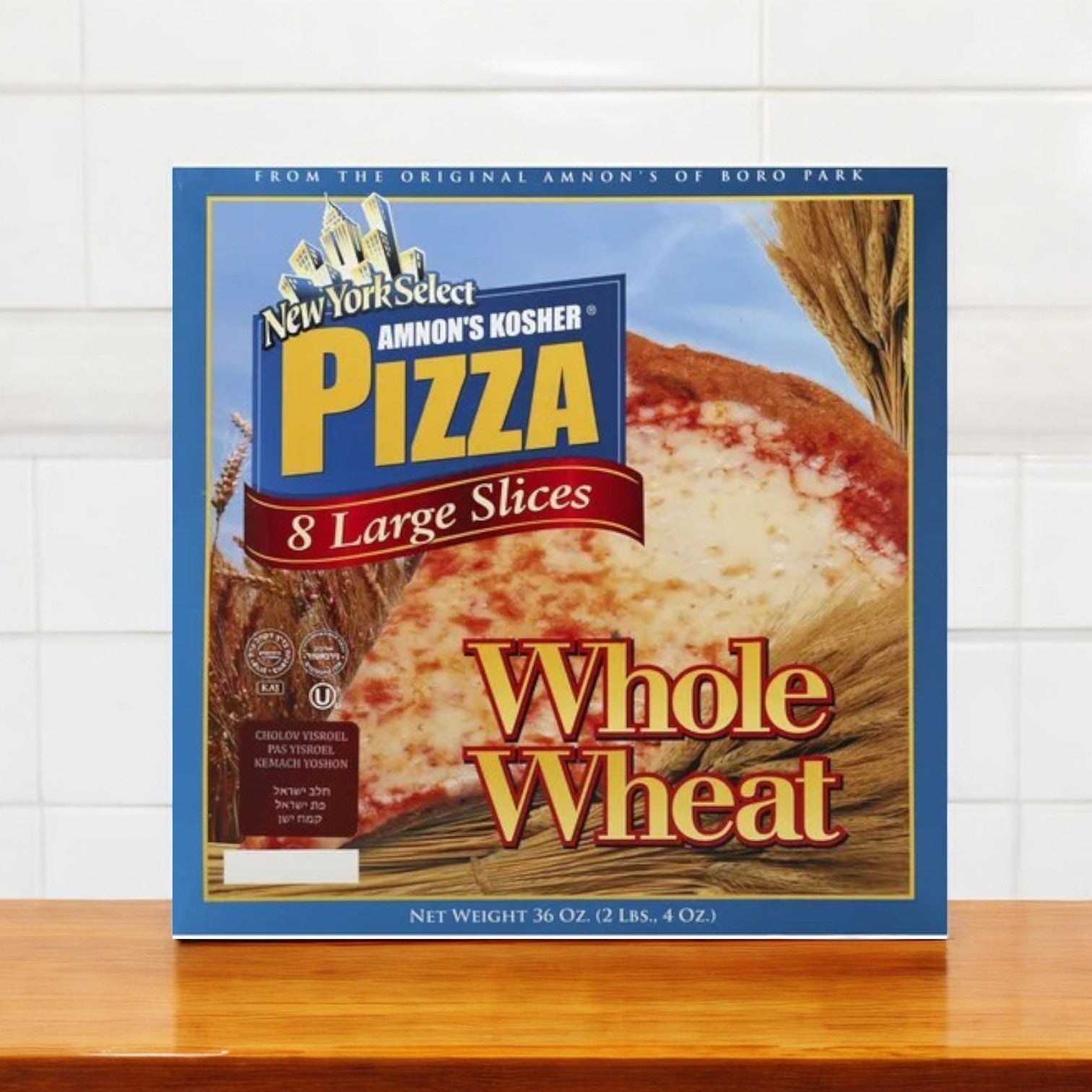 A box of Amnon's Kosher Pizza Whole Wheat Frozen, 36 oz, featuring a wooden surface and tiled background.