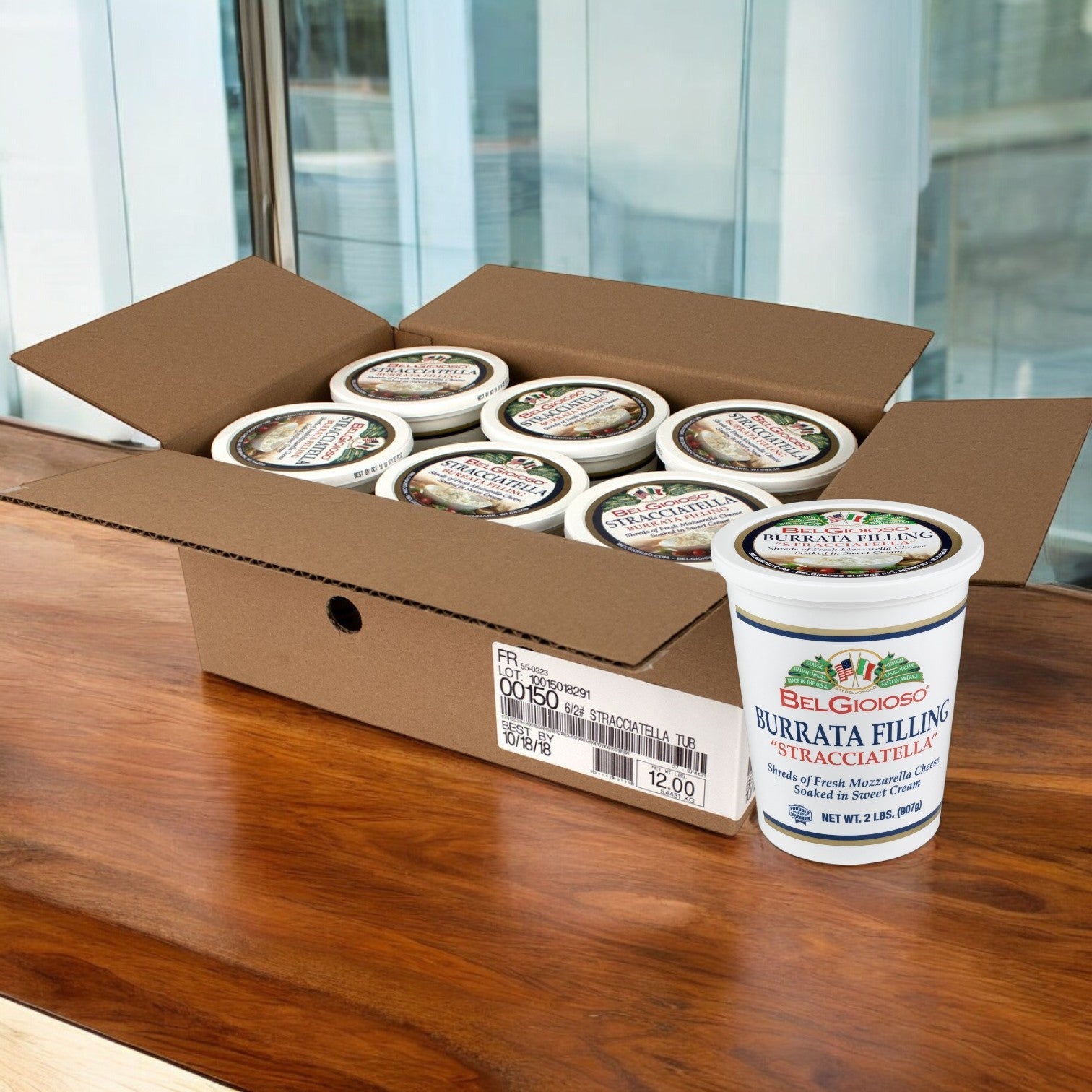 Displayed on a wooden surface, a box of BelGioioso Mozzarella Stracciatella Cups (6/2 LB) highlights one in front. Made from fresh cow's milk, Belgioioso delivers an irresistibly creamy texture that cheese connoisseurs will love.