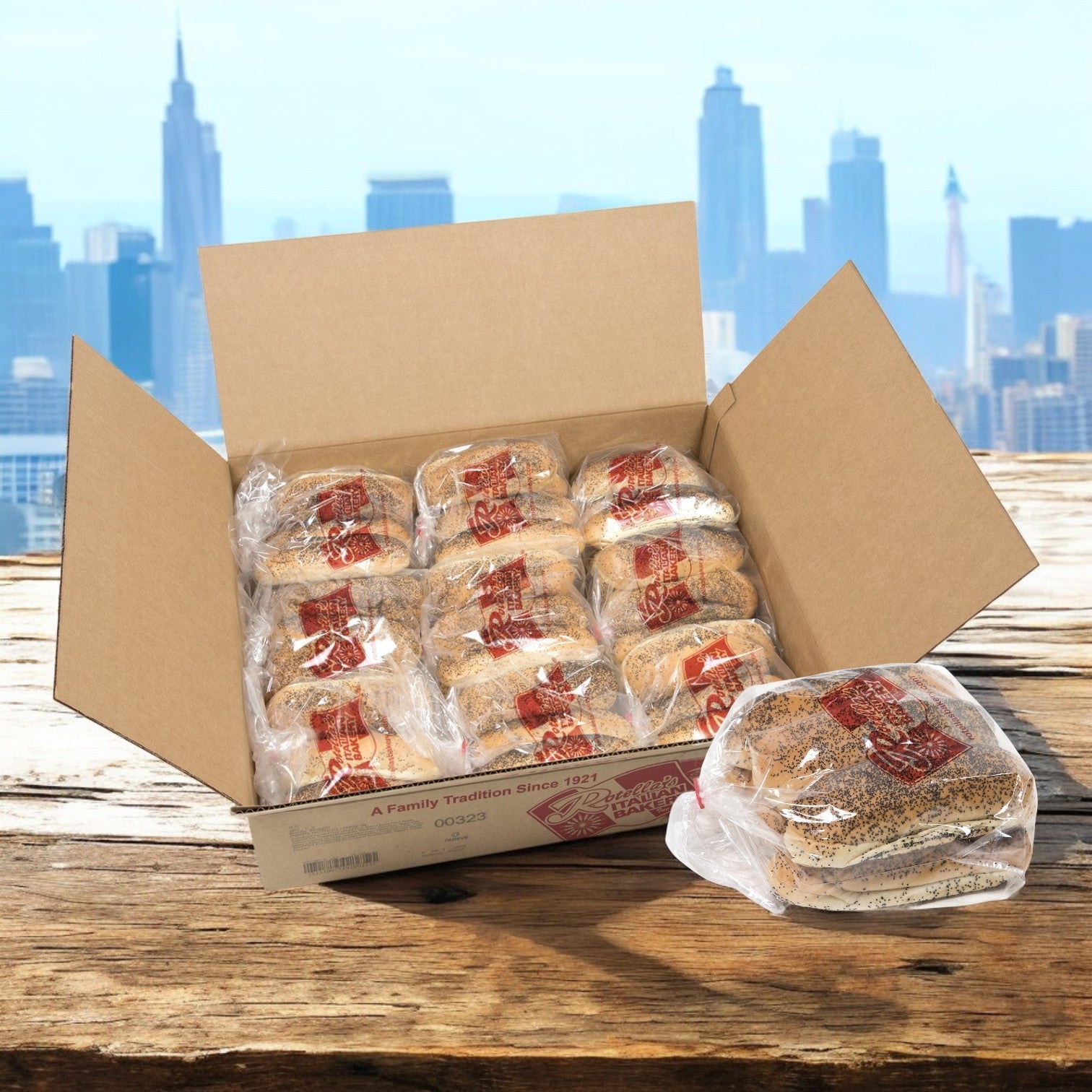 A cardboard box of Rotella Poppyseed Sliced Hot Dog Buns, 5.5", 54 Count Case, sits on a wooden surface with the vibrant city skyline in the background.