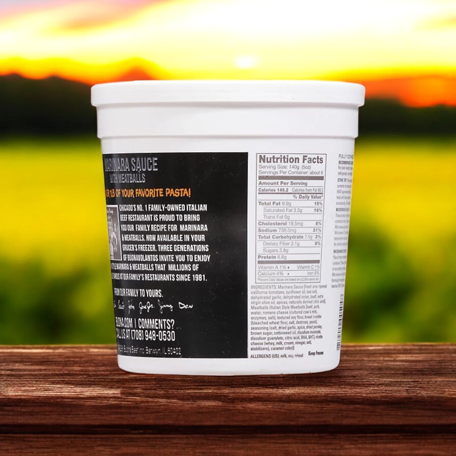 A pack of Buona Marinara Sauce & Meatballs, 3 Packs of 32 oz., sits on a wooden surface with a blurred outdoor landscape, promising to enhance your meal. The label includes instructions and nutritional info, perfect for pairing with meatballs.
