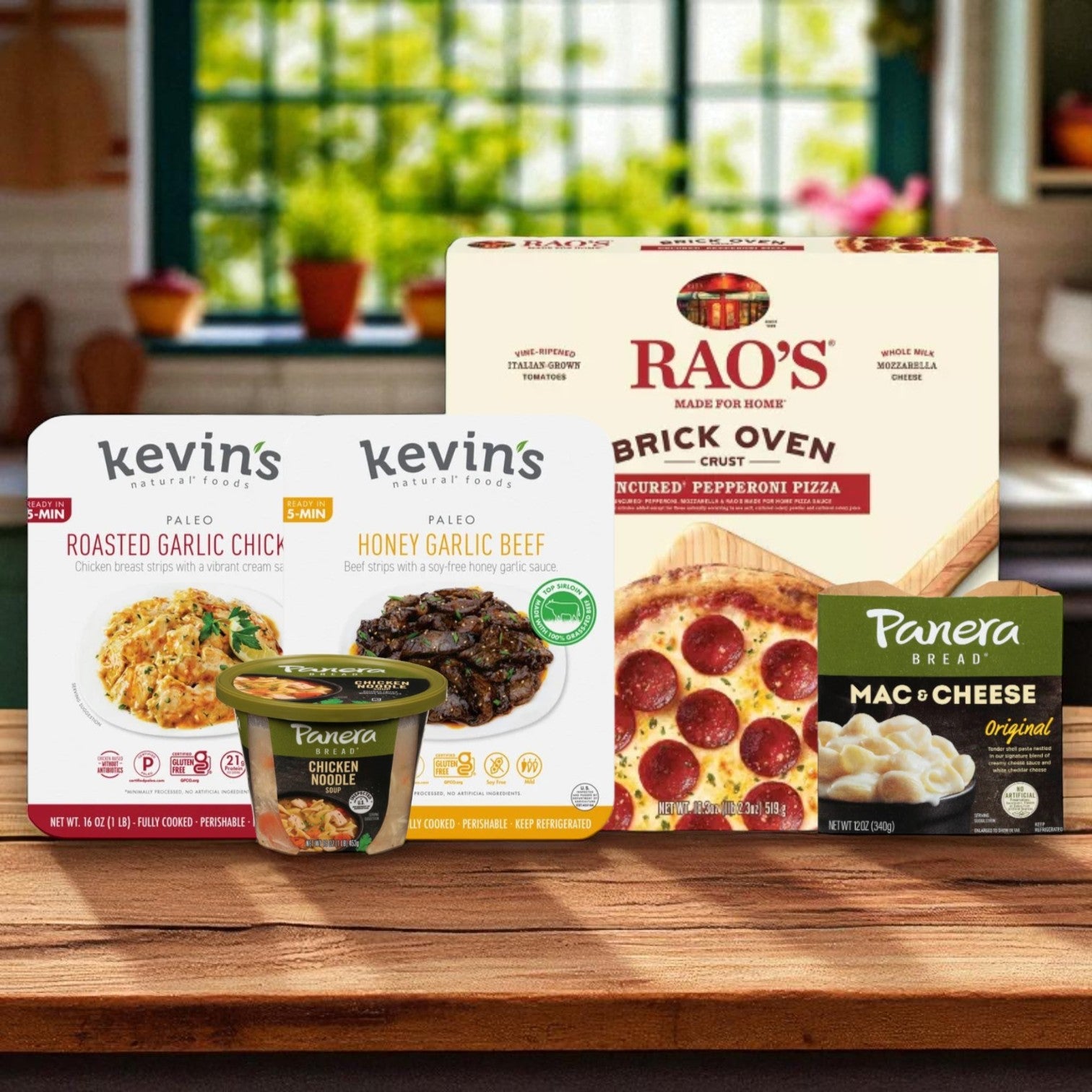Ready-to-heat meals and pizza from Endless Market’s College Food Box—including Kevin’s beef & chicken, Panera soup & mac, and Rao’s pepperoni pizza—displayed on a wooden surface indoors.
