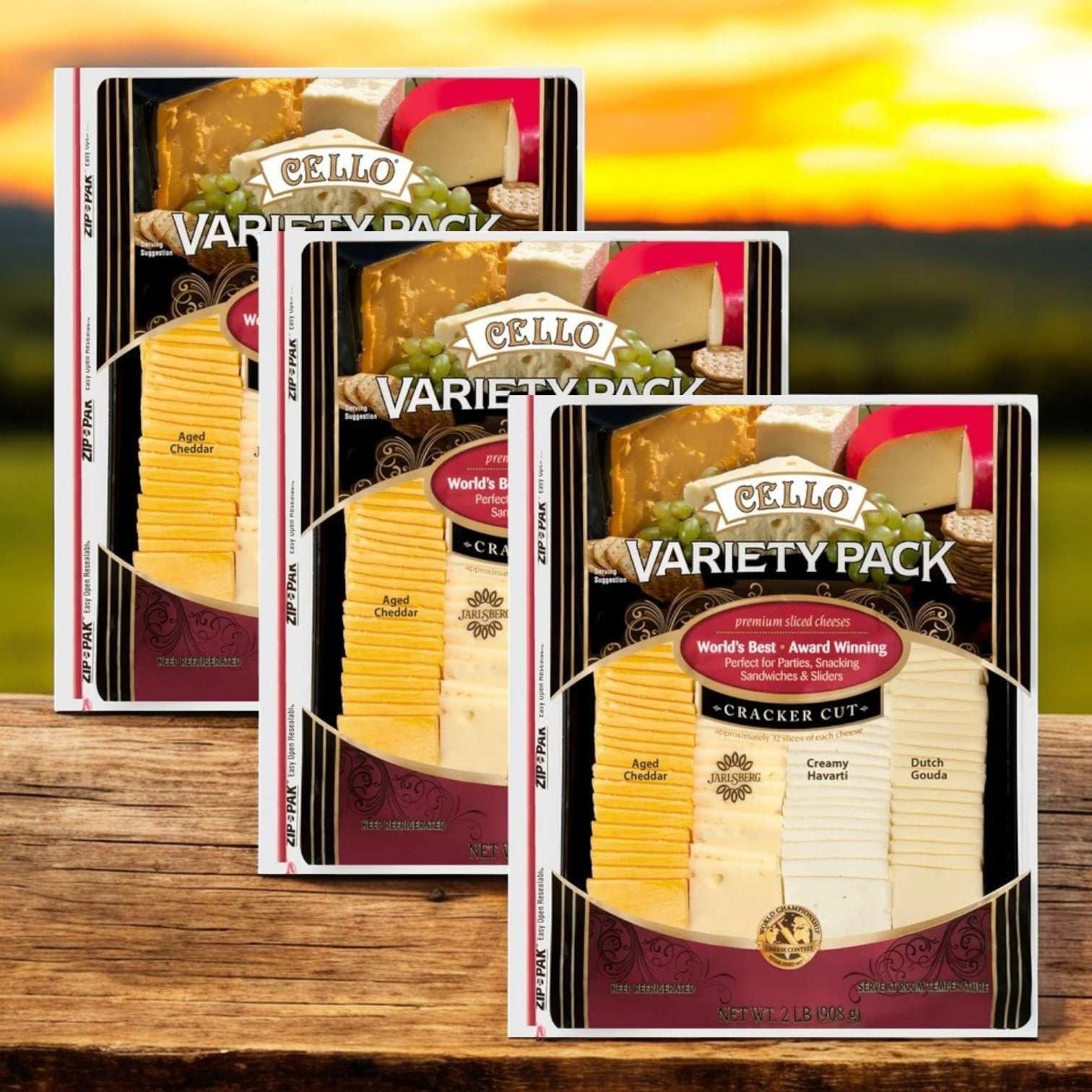 Three packs of Cello's Variety Pack, Cracker Cut Premium Sliced Cheeses (2 lbs. each), are displayed on wood with a sunset backdrop. Each pack features slices of Asiago, Creamy Havarti, and Dutch Gouda—ideal for enhancing your charcuterie board.