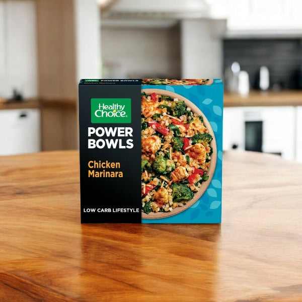 A box of Healthy Choice Power Bowl Variety Pack sits on a wooden kitchen counter, featuring a tempting meal image. With nutritious, microwaveable options, Healthy Choice offers convenient and wholesome dining.