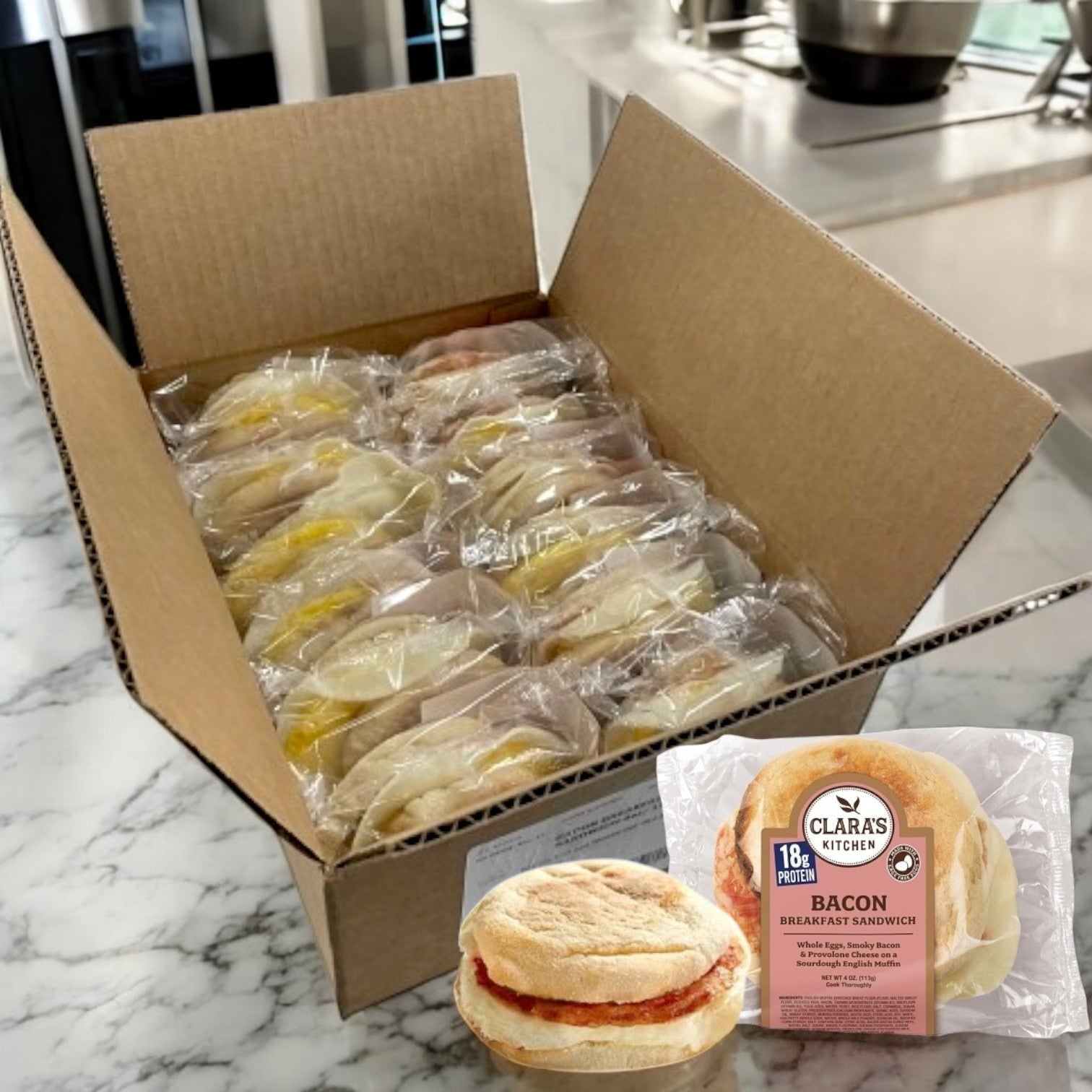 A case of Clara's Kitchen Individually Packaged Bacon Breakfast Sandwiches – 12 Per Case sits elegantly on a marble countertop, showcasing the perfect solution for on-the-go breakfasts.
