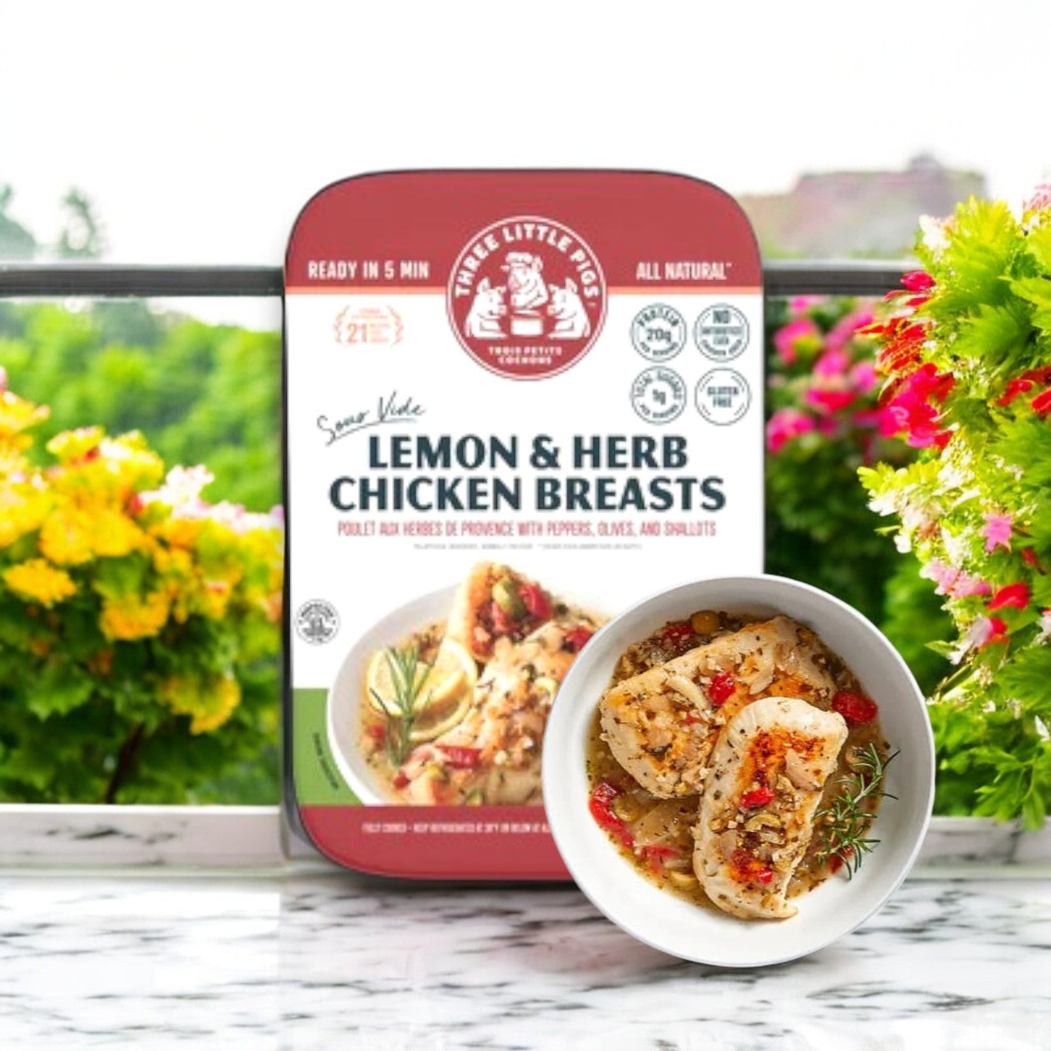 The Three Little Pigs – Sous-Vide Lemon & Herb Chicken (16 oz.) by Three Little Pigs Trois Petits Cochons is showcased on a countertop. The packaging emphasizes cooking time and natural ingredients, while the dish in a white bowl ensures fork-tender, restaurant-quality chicken in every bite.