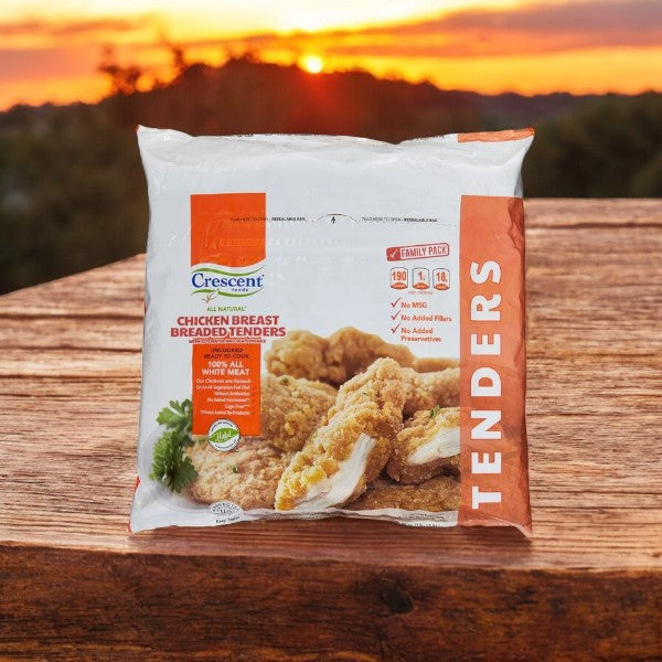 A 3-lb bag of Crescent Foods Chicken Breast Breaded Tenders sits elegantly on a wooden surface, set against a stunning sunset background.