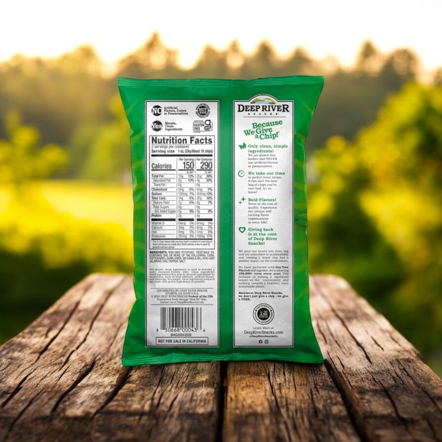 A bag of Deep River Snacks Zesty Jalapeño Kettle Potato Chips rests on a wooden table outdoors, showcasing its gluten-free benefits and eco-conscious branding.