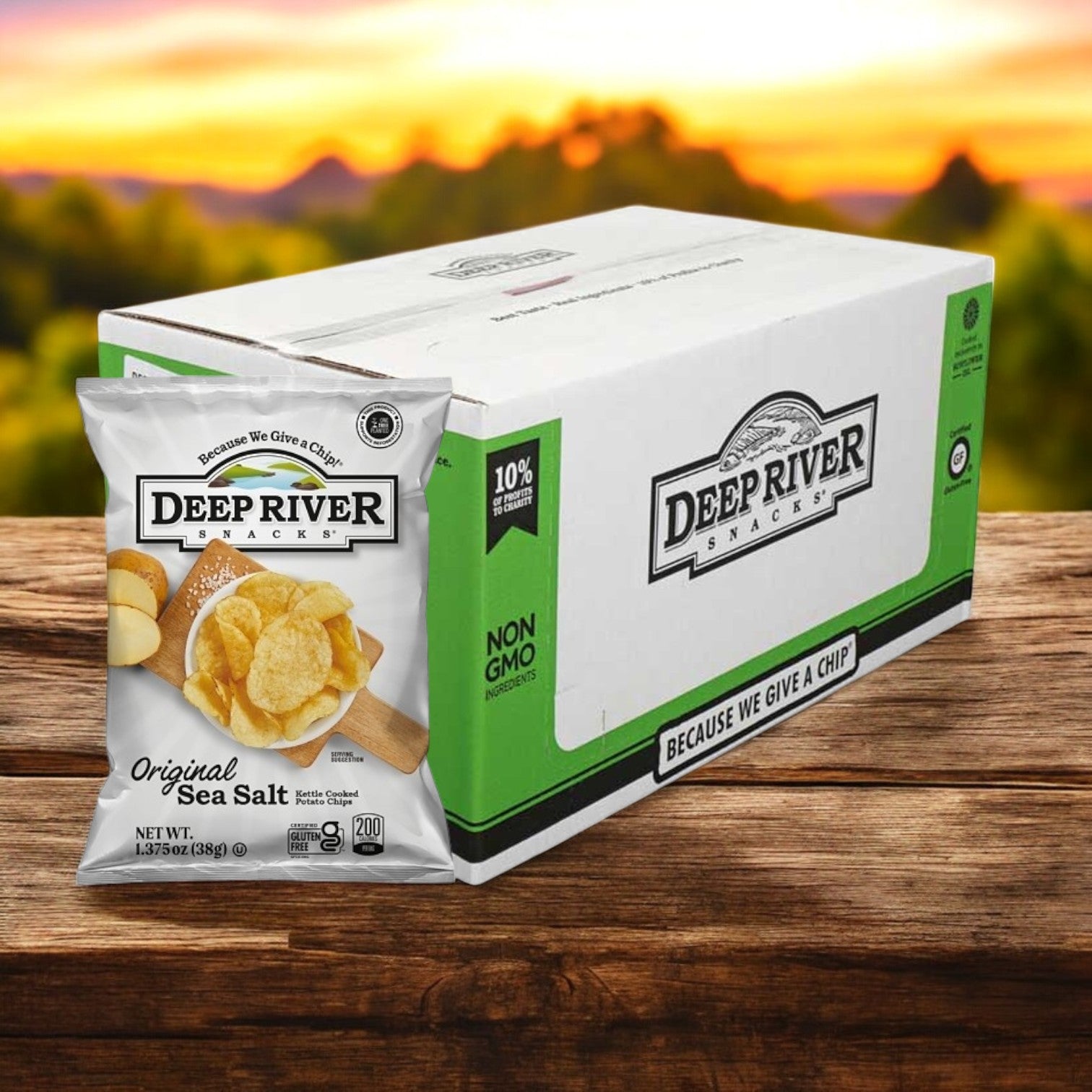 A bag of Deep River Snacks Original Sea Salt Kettle Potato Chips, gluten-free, is shown beside a large box on a wooden surface with a blurred outdoor background.