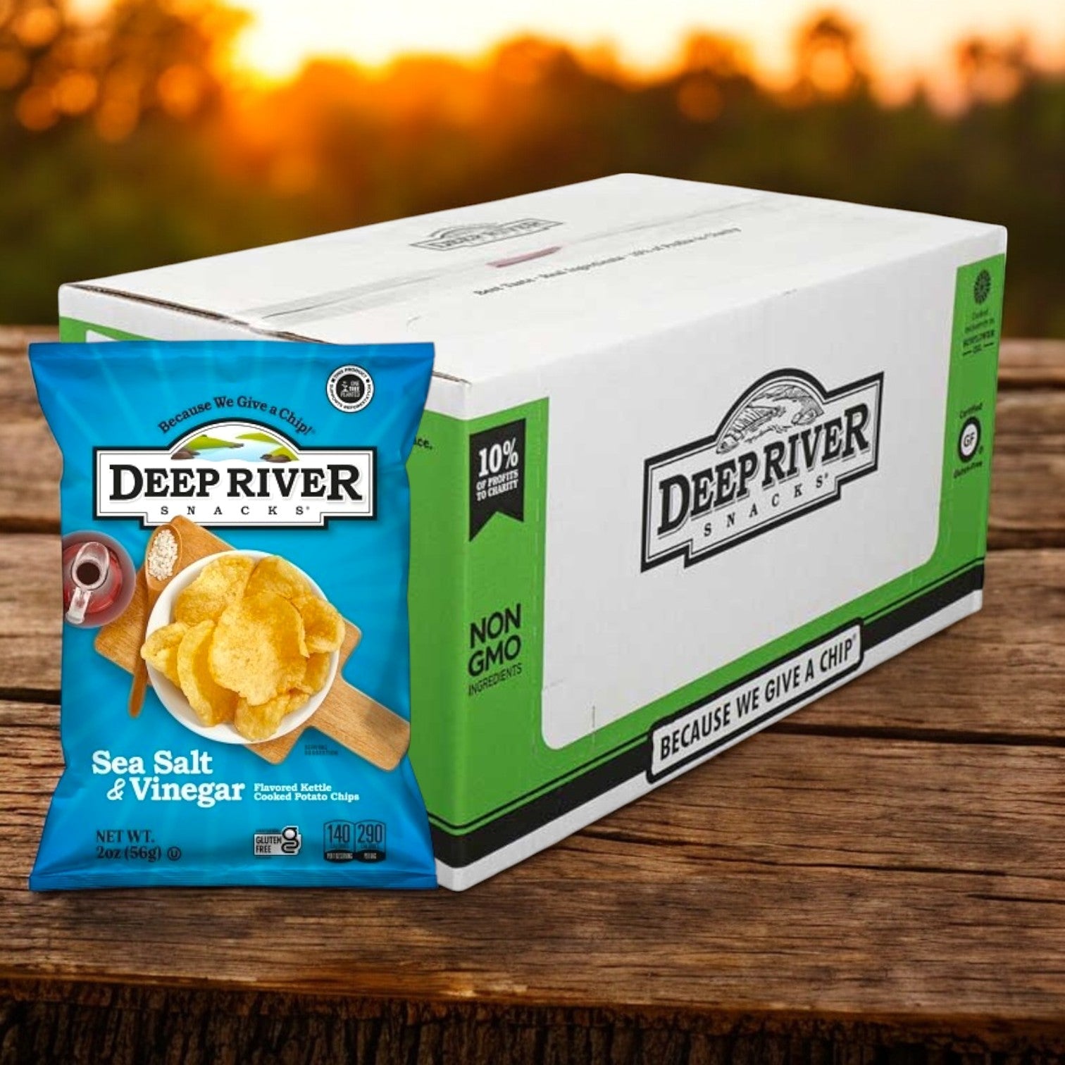 In front of a white box with matching branding, a 2-ounce bag of Deep River Snacks Salt & Vinegar Kettle Potato Chips stands out against a blurred outdoor backdrop. Crafted with premium ingredients, these allergen-friendly chips offer a satisfying crunch with every bite. 24 per case.