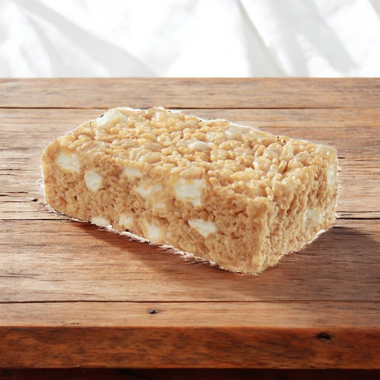 A Sweet Street Dessert Bar Marshmallow, 2.1 oz., rests on a wooden surface, highlighting its chewy marshmallow texture.