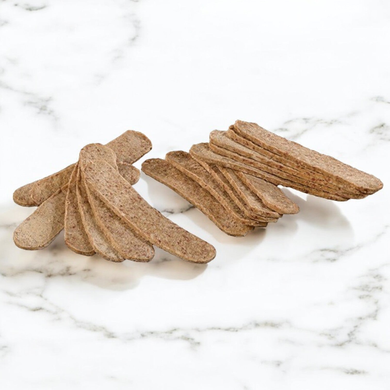 Two piles of Devanco Foods Halal Off the Cone Gyro Slices, arranged on a white marble surface, reminiscent of authentic Italian taste.