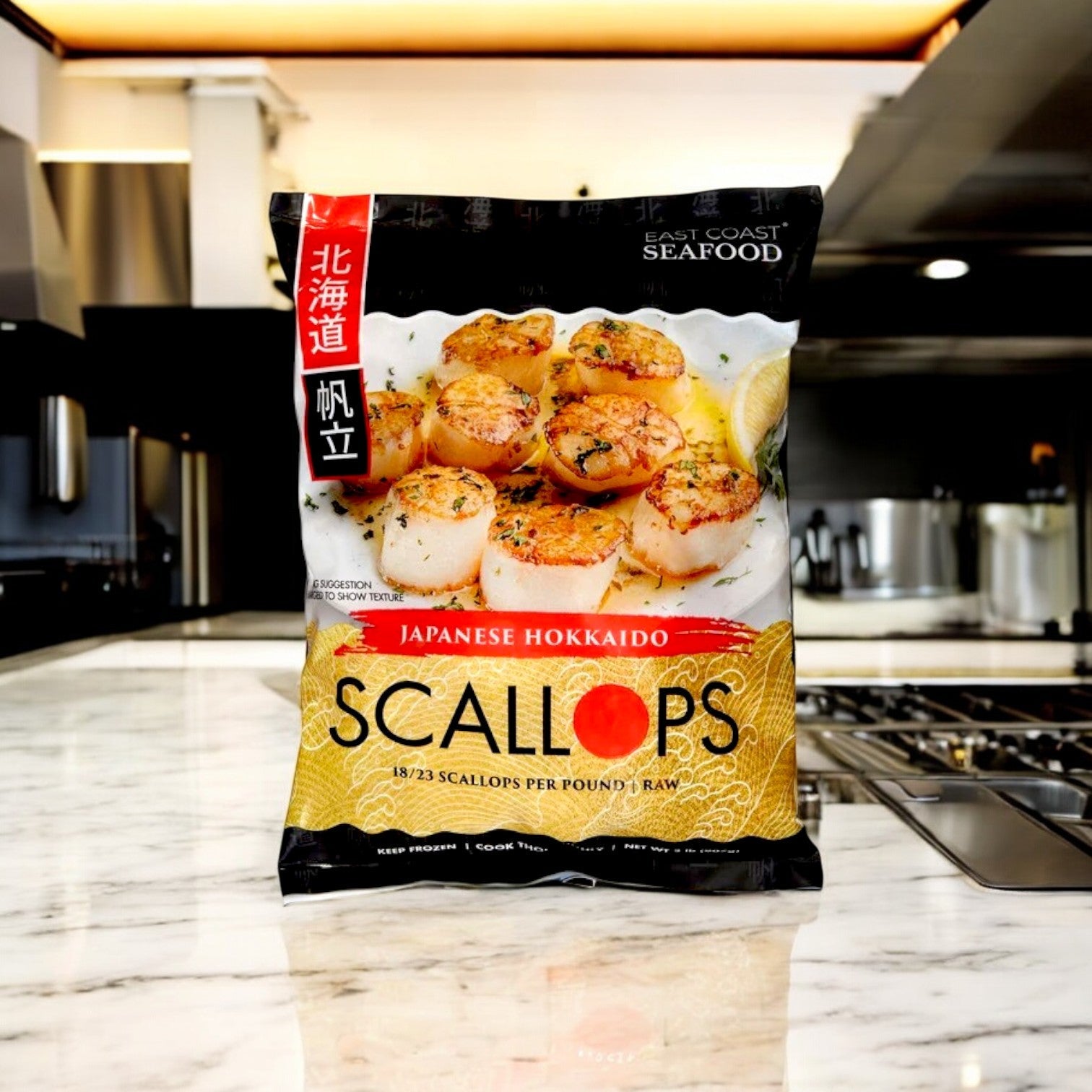 A bag of Kirkland Signature East Coast Seafood Japanese Hokkaido Scallops, Raw, 18-23 ct, 2 lbs is displayed on a marble countertop, showcasing premium wild-caught scallops in a modern kitchen setting.