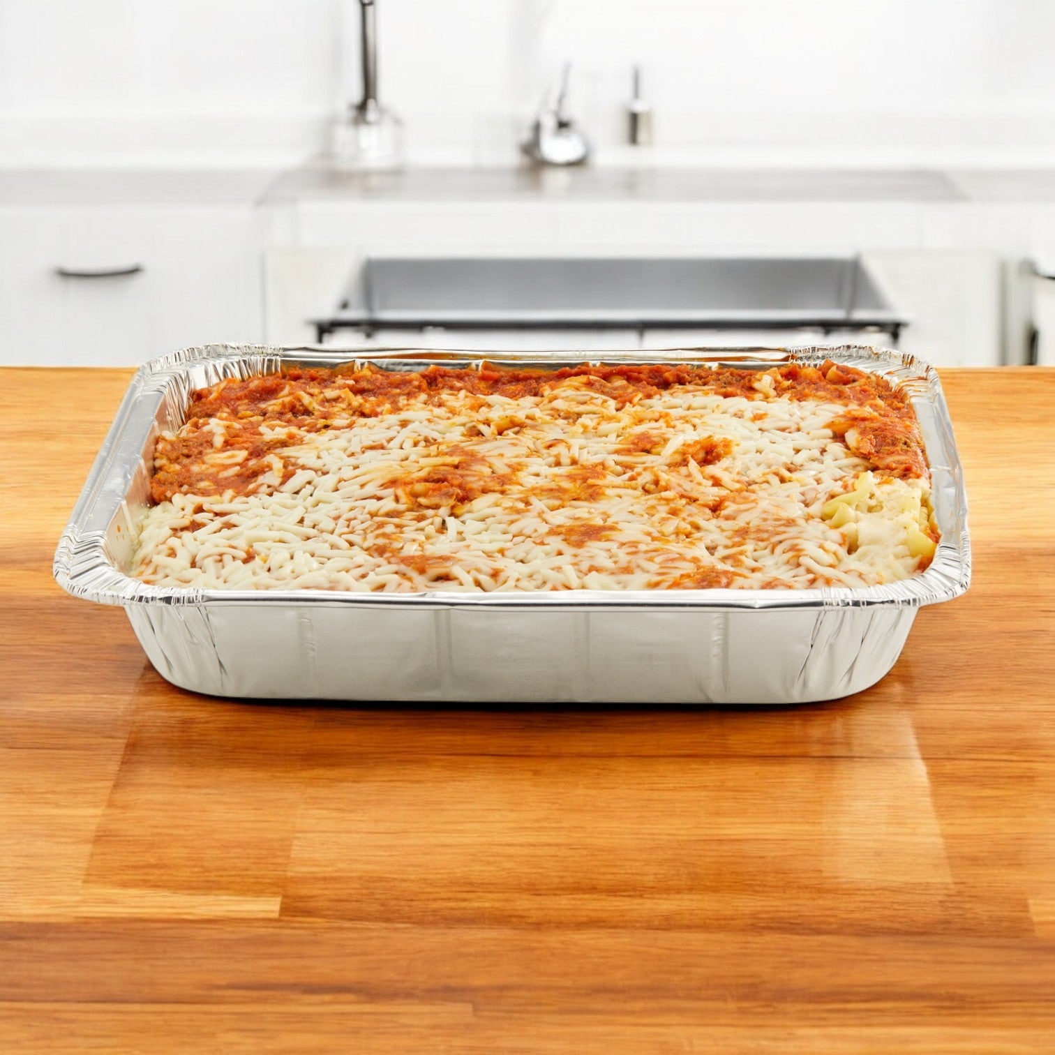 On a wooden kitchen countertop, a tray from Stouffer's Entree Lasagna Meat offers a convenient meal solution for busy evenings.