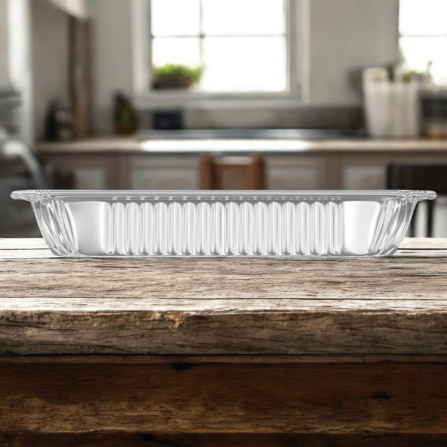 A Sysco Classic rectangular glass baking dish sits on a wooden table in the kitchen, ready with trays of rich and creamy Sysco Classic Entree Macaroni And Cheese, 4.5 lbs. - 1 Case, 4 Trays.