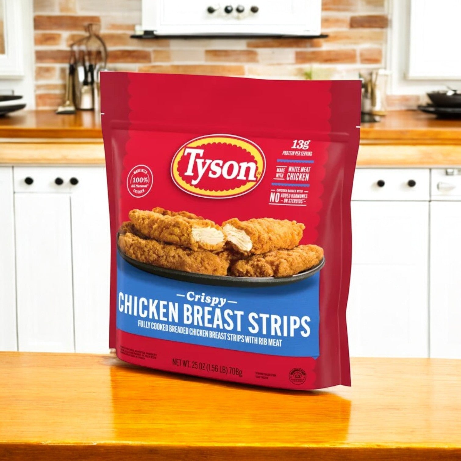 A red package of Tyson All Natural Crispy Chicken Strips – Frozen, 25 oz -3 Count sits on the kitchen counter, displaying images and details about the all-natural product—ideal for anyone craving delicious crispy chicken strips straight from the freezer.