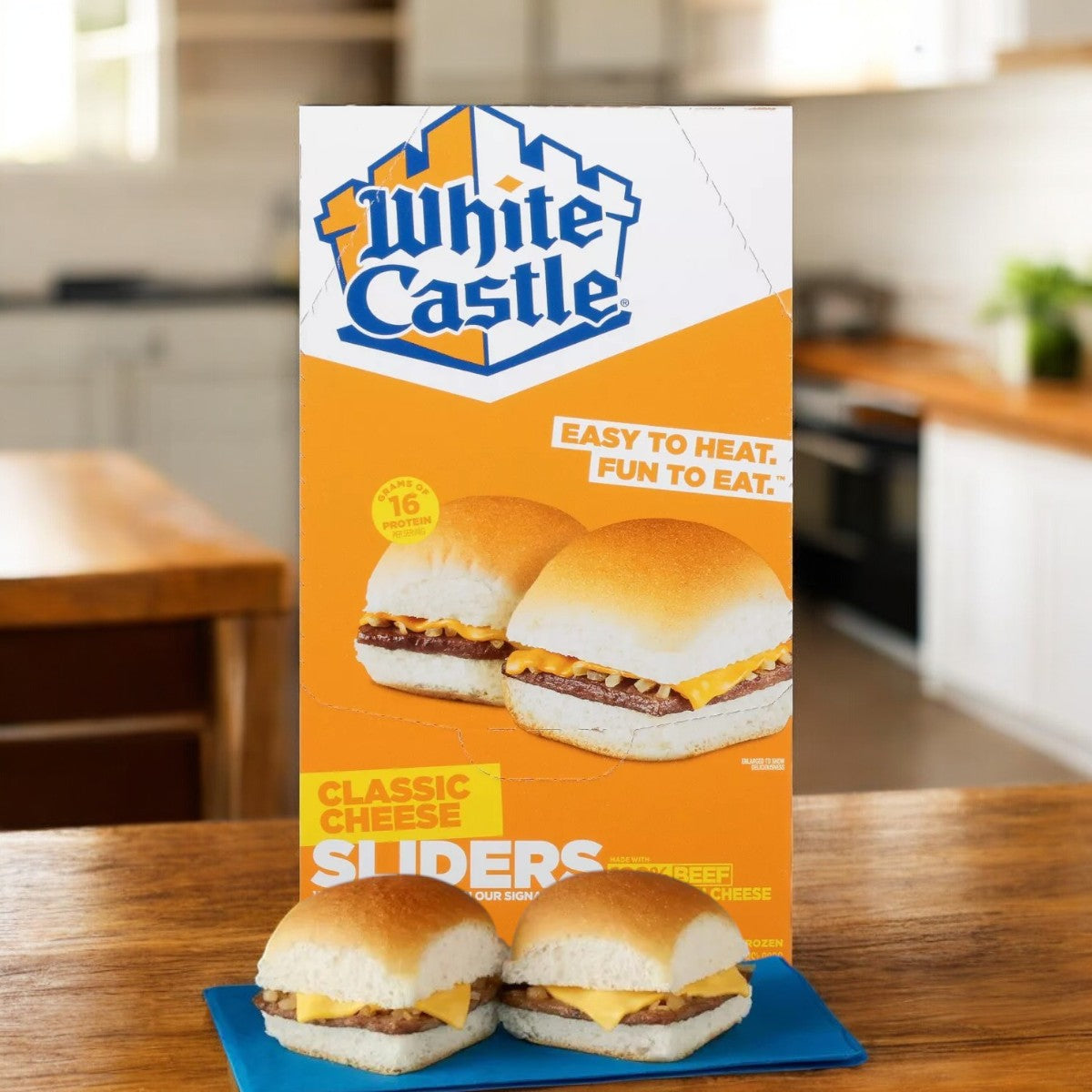 A White Castle Microwaveable Frozen Cheeseburger Slider sits on a kitchen counter, with a perfectly cooked slider on a blue plate in the foreground.