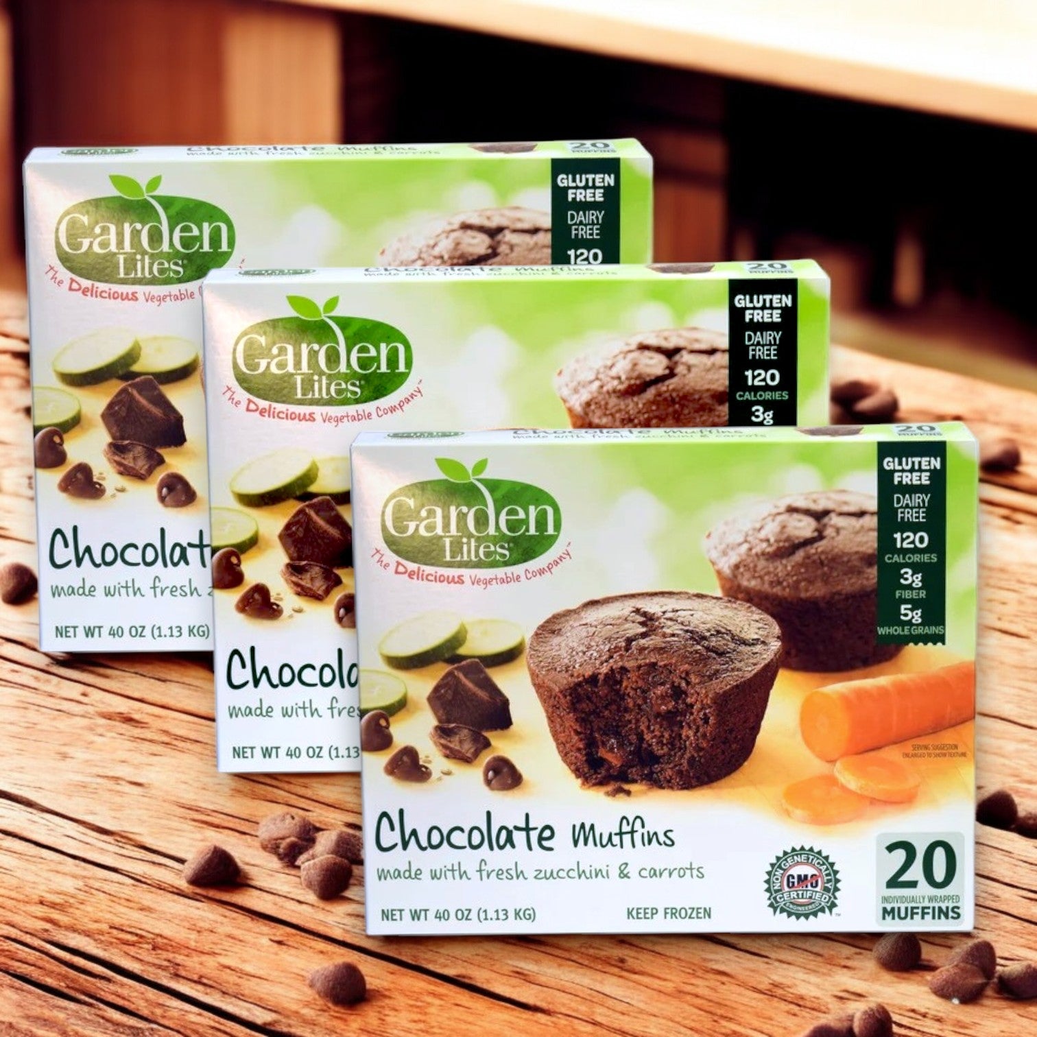 Garden Lites Chocolate Muffins by Veggies Made Great sit on a wooden surface, sprinkled with chocolate chips. These gluten-free muffins are dairy-free, packed with zucchini and carrots, creating the perfect chocolate treat.