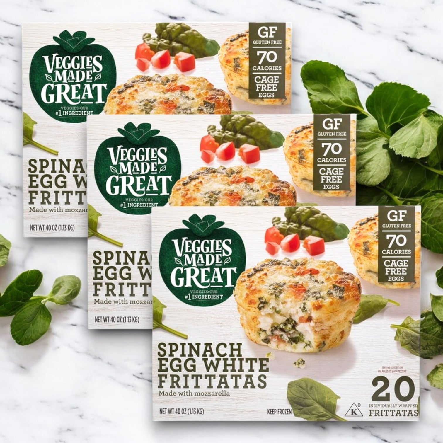 Three boxes of Veggies Made Great Garden Lites Vegetarian Spinach & Egg White Frittata (60-Count) are on a marble surface, offering a total of 60 individually wrapped vegetarian frittatas. Ideal as a low-calorie snack or high-protein breakfast!.
