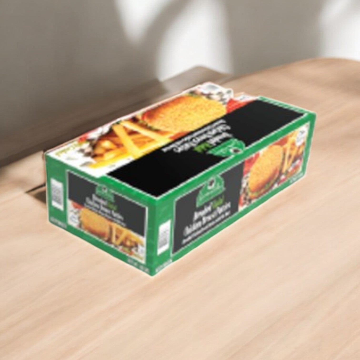 A 10 lbs box of Garden Valley Breaded Halal Chicken Breast Patties, fully cooked, rests on a wooden table in sunlight.