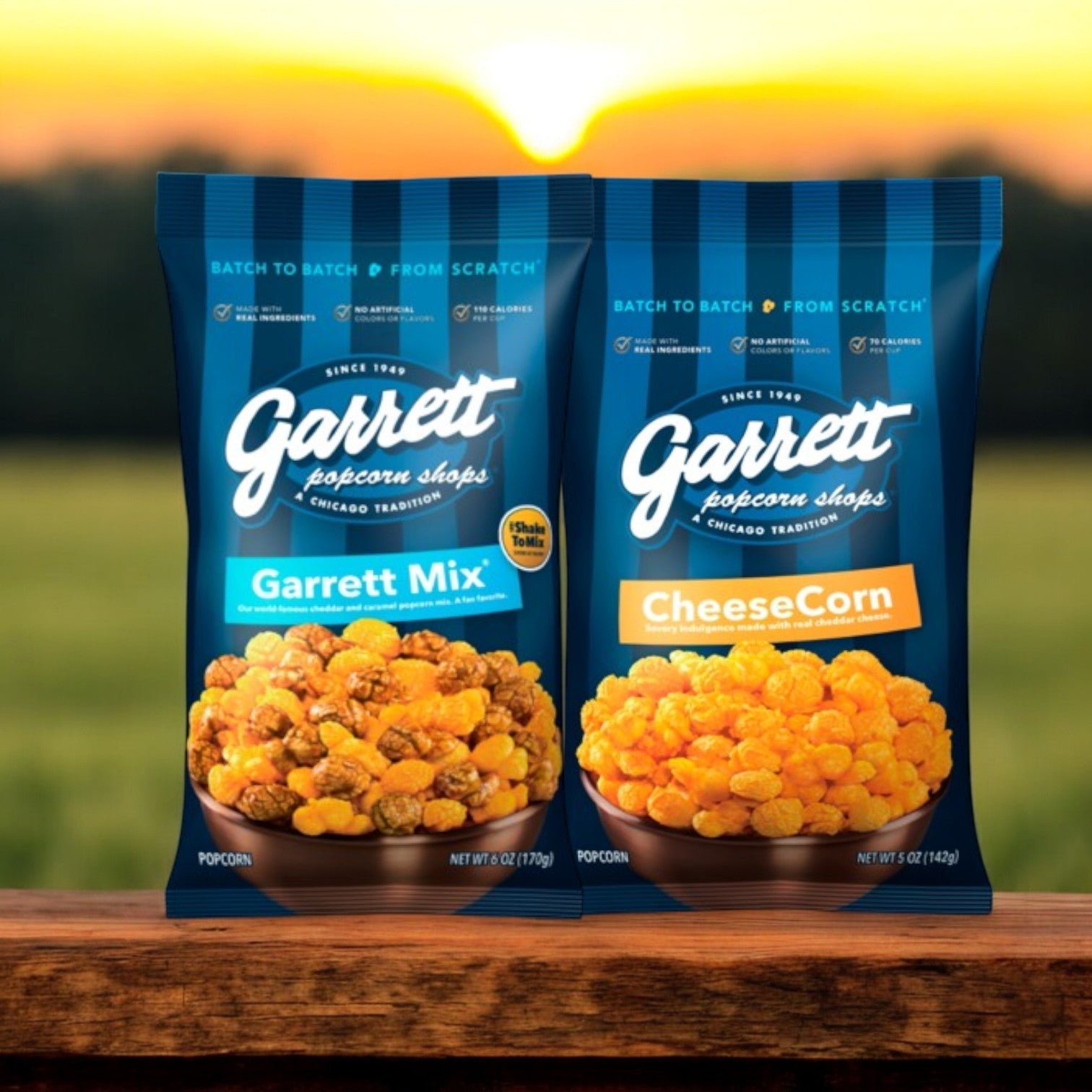 Two bags of Garrett Popcorn Combo Pack – Garrett Mix (6 oz) & CheeseCorn (5 oz) lie on a wooden surface, showcasing the delicious cheddar cheese and caramel popcorn blend, set against a blurred outdoor background.