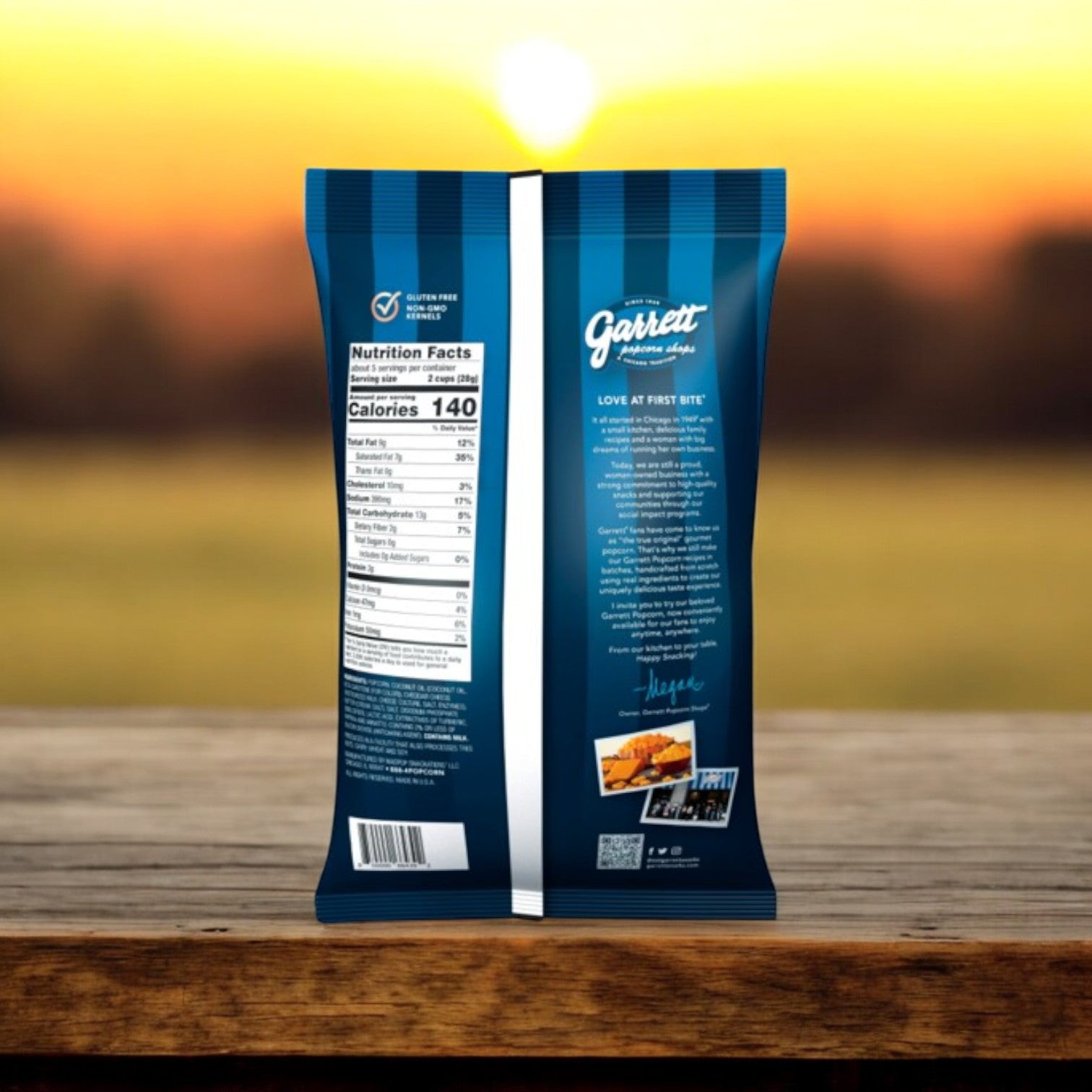 A Garrett Popcorn Combo Pack, including Garrett Mix (6 oz) and CheeseCorn (5 oz), sits on a wooden surface with cheddar cheese details and nutritional info on the back, set against a blurred sunset.