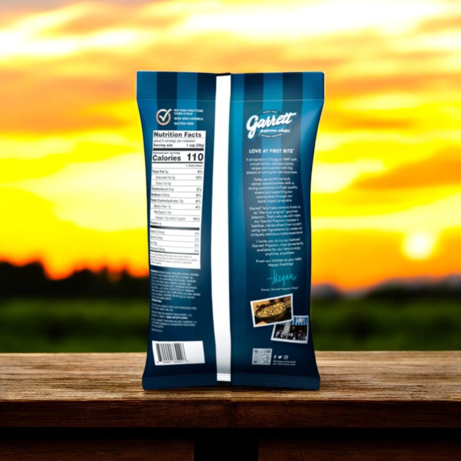 A Garrett Popcorn Combo Pack - Garrett Mix (6 oz) & CheeseCorn (5 oz) bag on a wooden surface with a sunset backdrop. Visible branding and nutritional details, with images of caramel popcorn and savory cheddar cheese adorning the design.