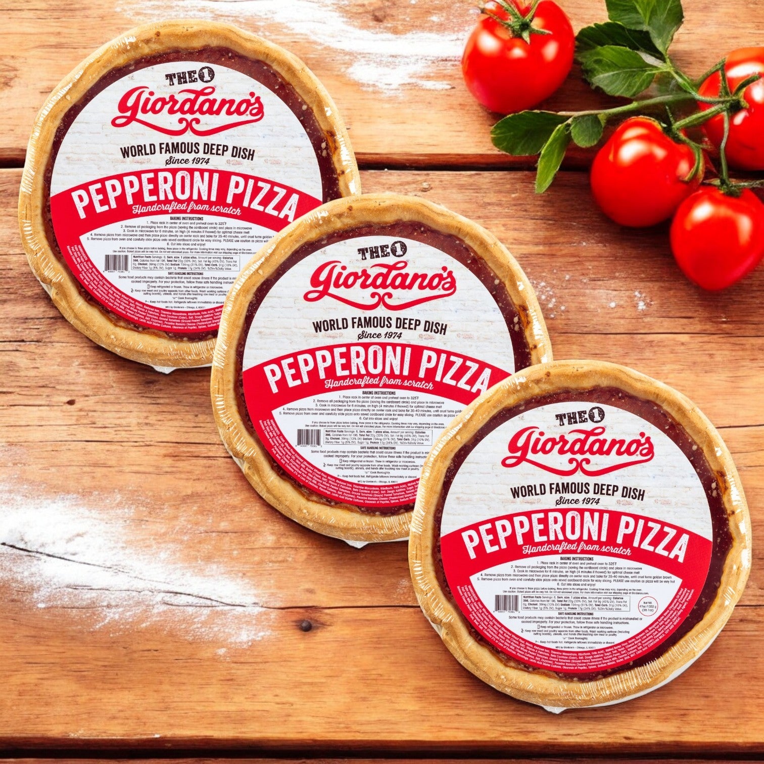 A trio of Giordano's, Frozen Deep Dish Stuffed Pepperoni Pizzas, 10" - 3 Pack, sits on a wooden surface with fresh tomatoes and basil.