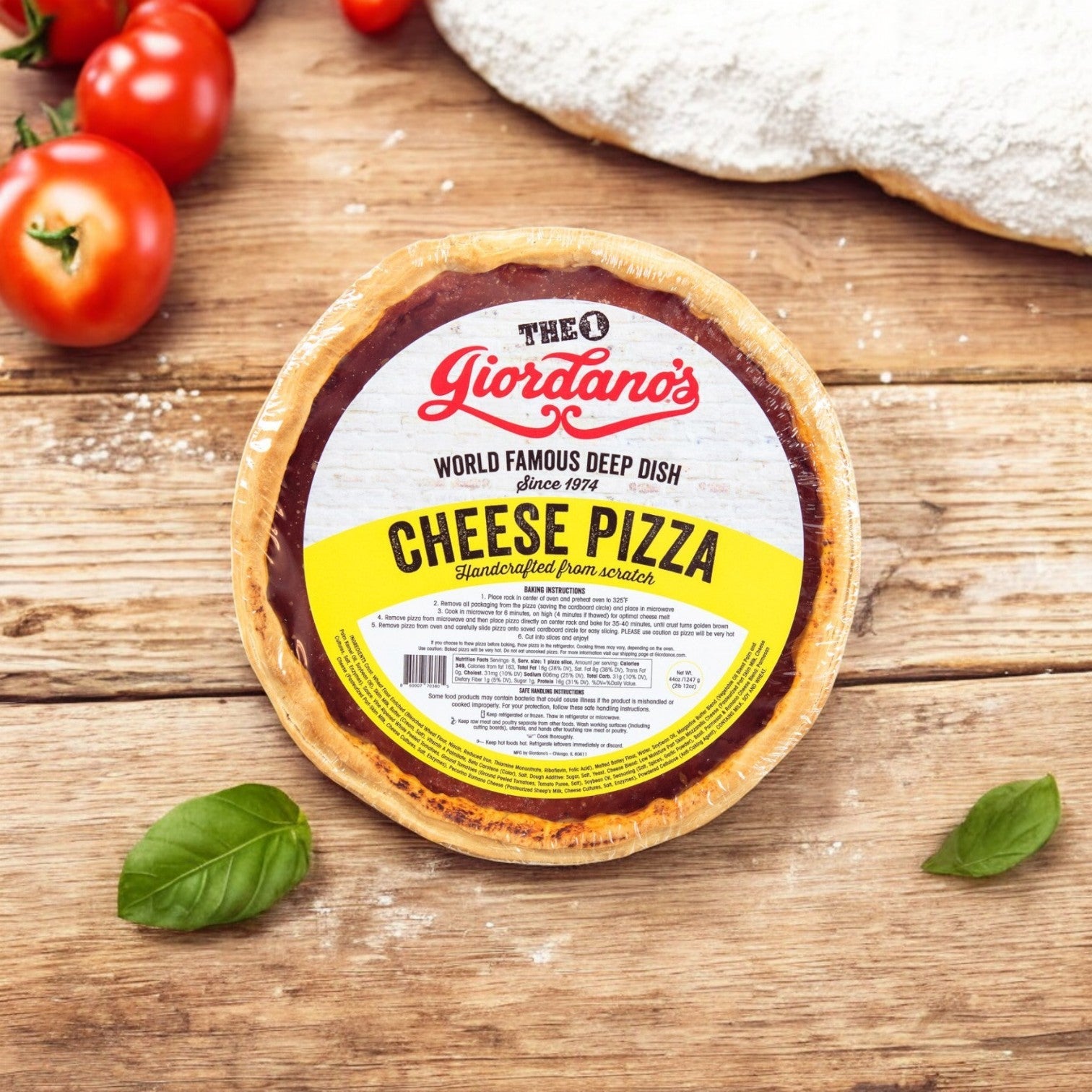 A Giordano's Frozen Deep Dish Stuffed Cheese Pizza, from the 10" - 3 Pack, sits on a wooden surface next to fresh tomatoes and basil leaves.