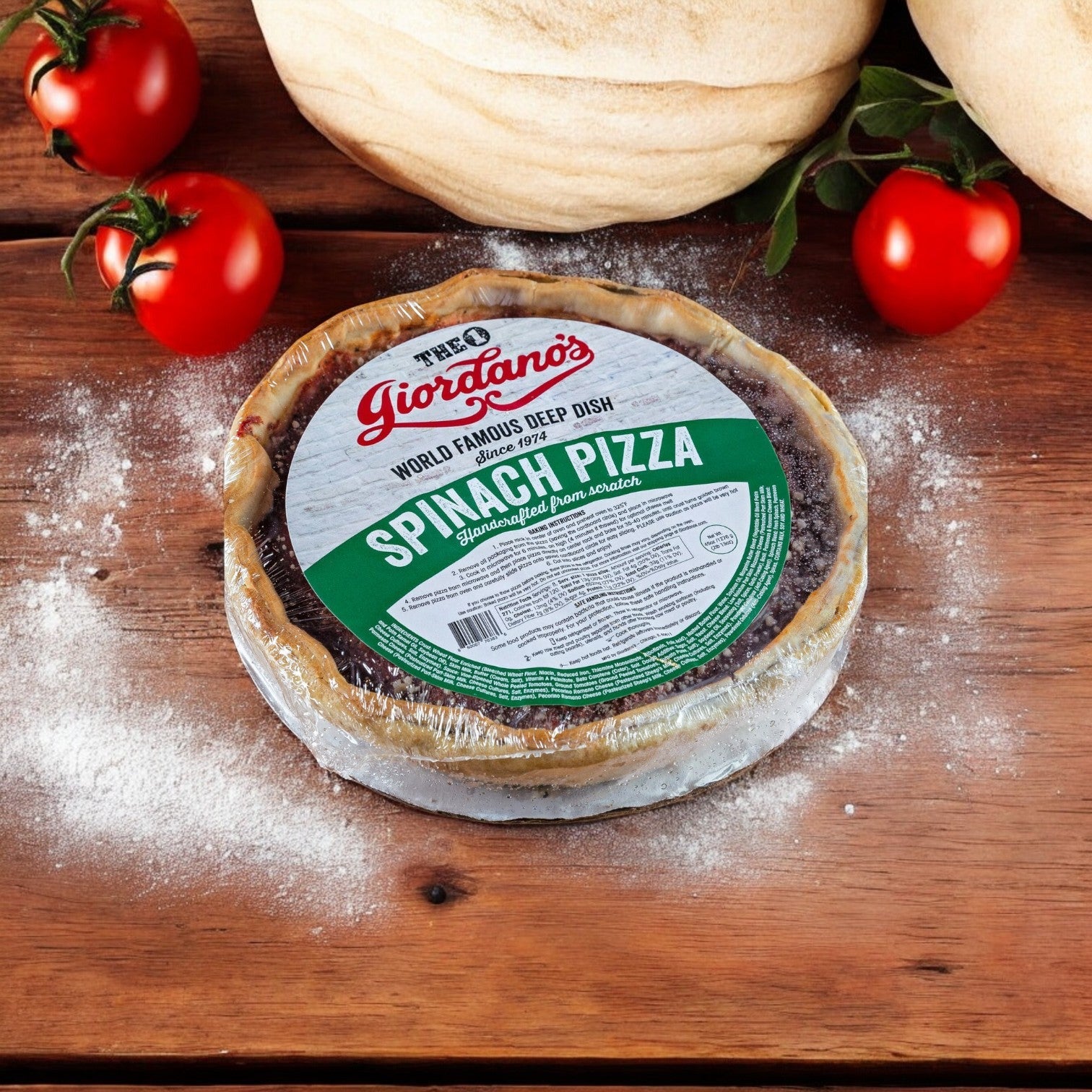A classic Chicago delight, Giordano's Frozen Deep Dish Stuffed Spinach Pizza, 10" - 3 Packs, sits on a wooden surface with flour and ripe tomatoes around.