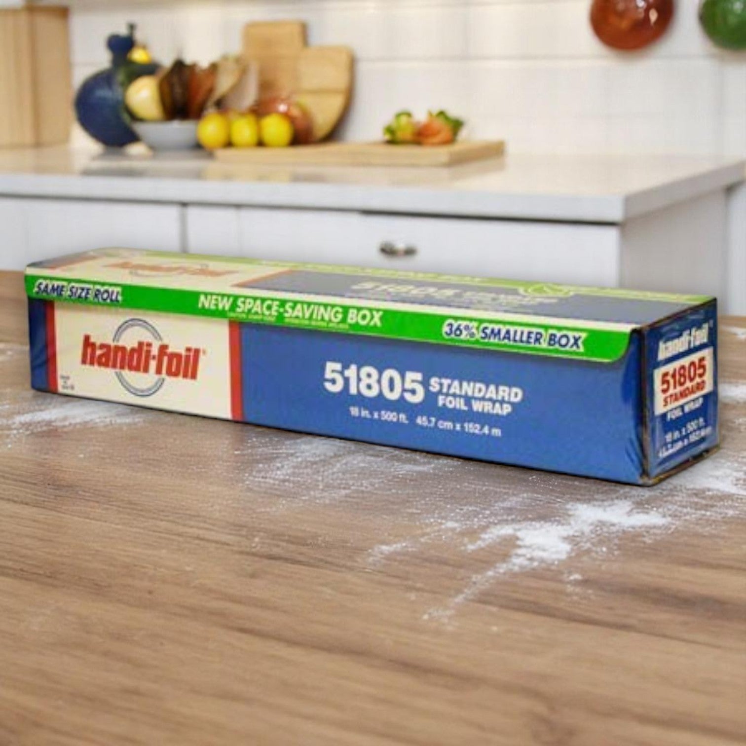A roll of Handi-Foil of America HFA 18" x 500' standard aluminum foil sits on a wooden kitchen counter with flour sprinkled nearby.